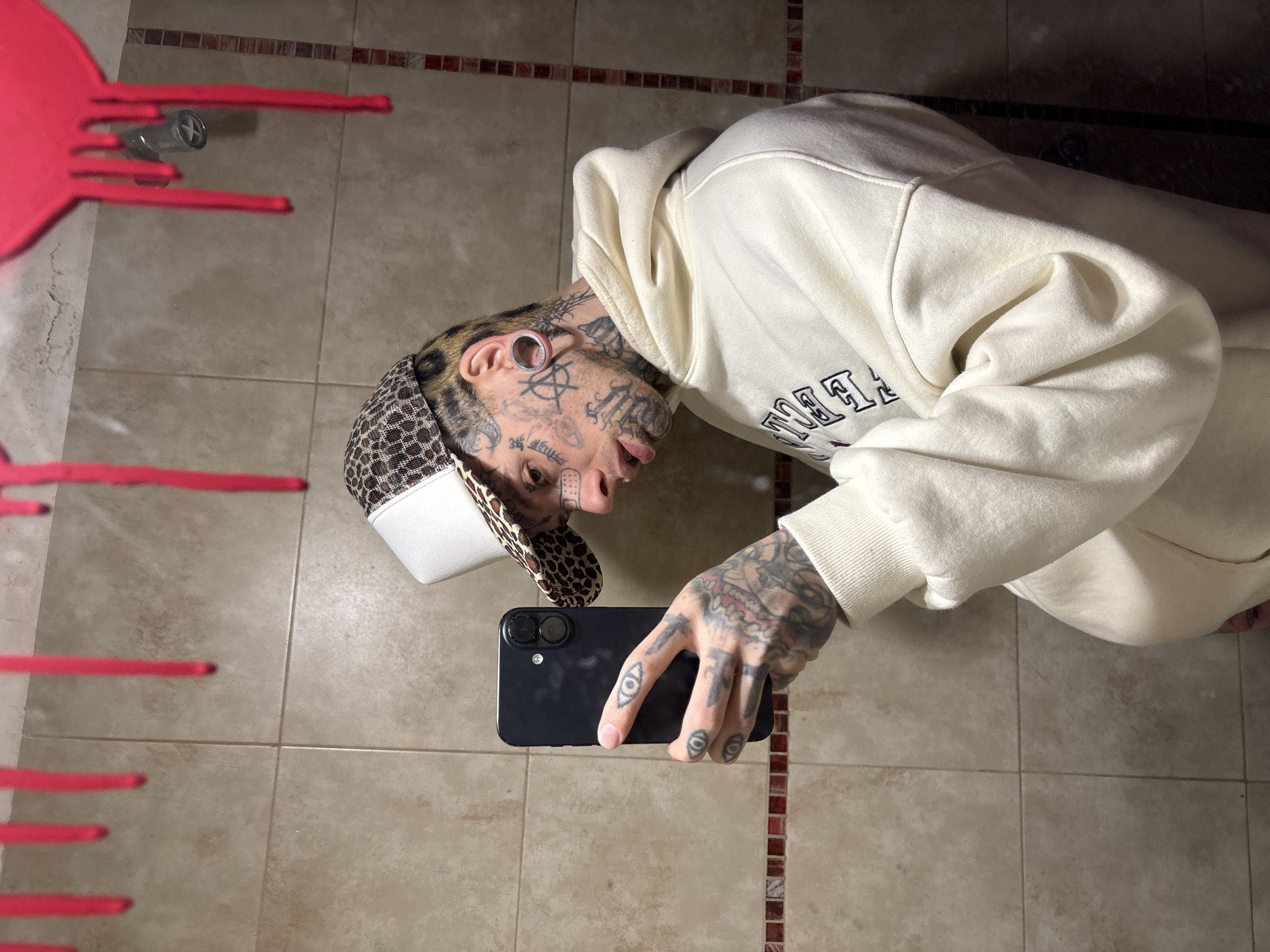 Tattooed individual takes bathroom selfie in Buenos Aires