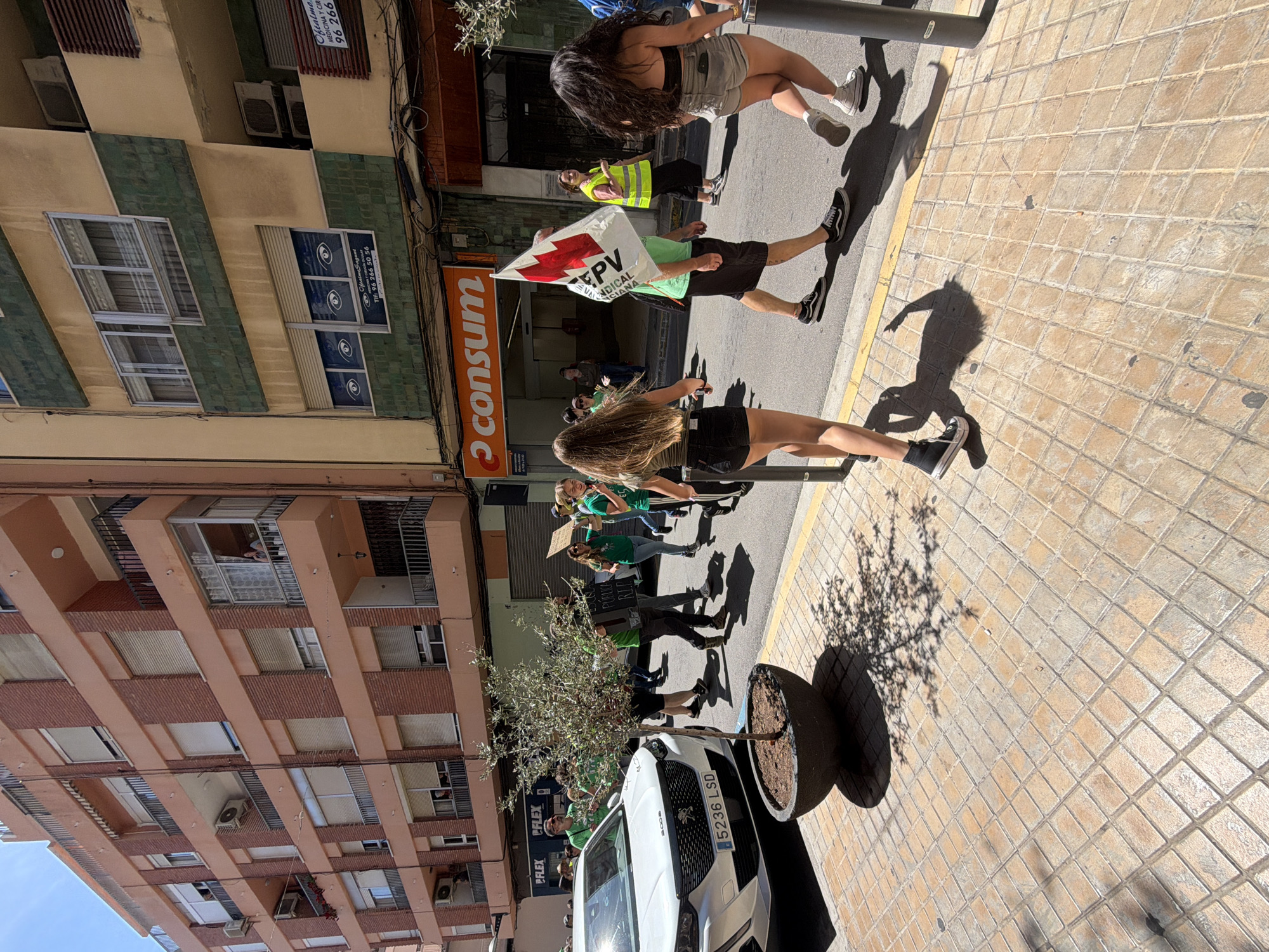 Green-shirted protesters march through Sagunto streets carrying Valencian banners