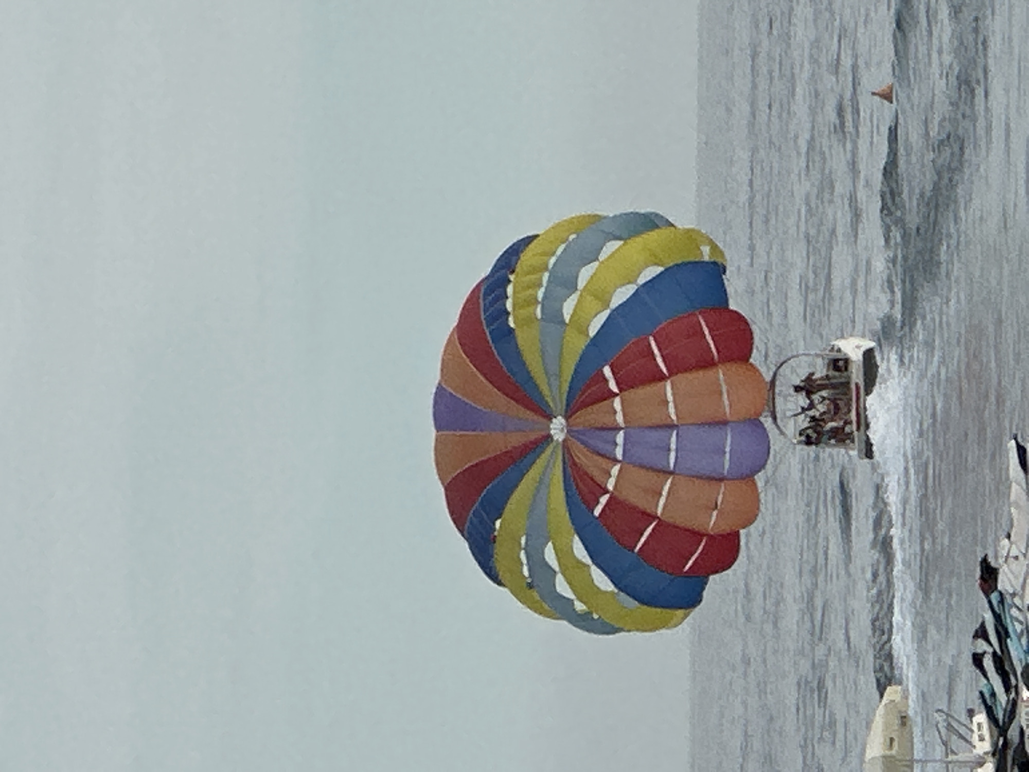 Colorful parasail floats above the Adriatic at Rafailovići