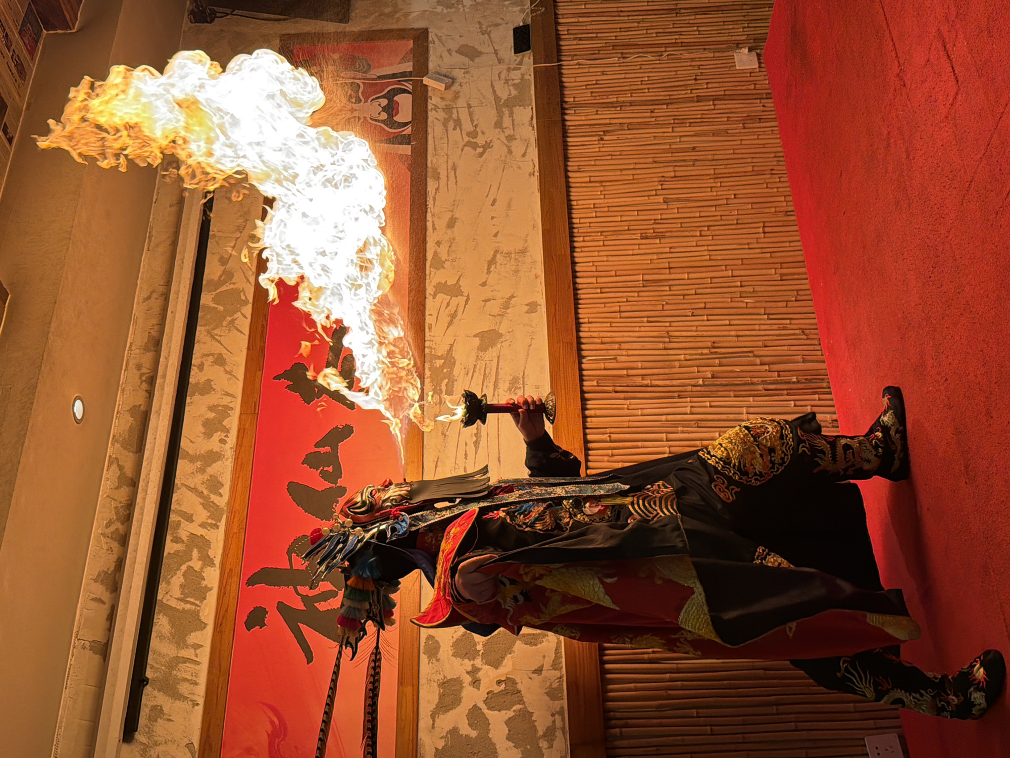 Ornate-costumed fire performer unleashes a dramatic flame plume