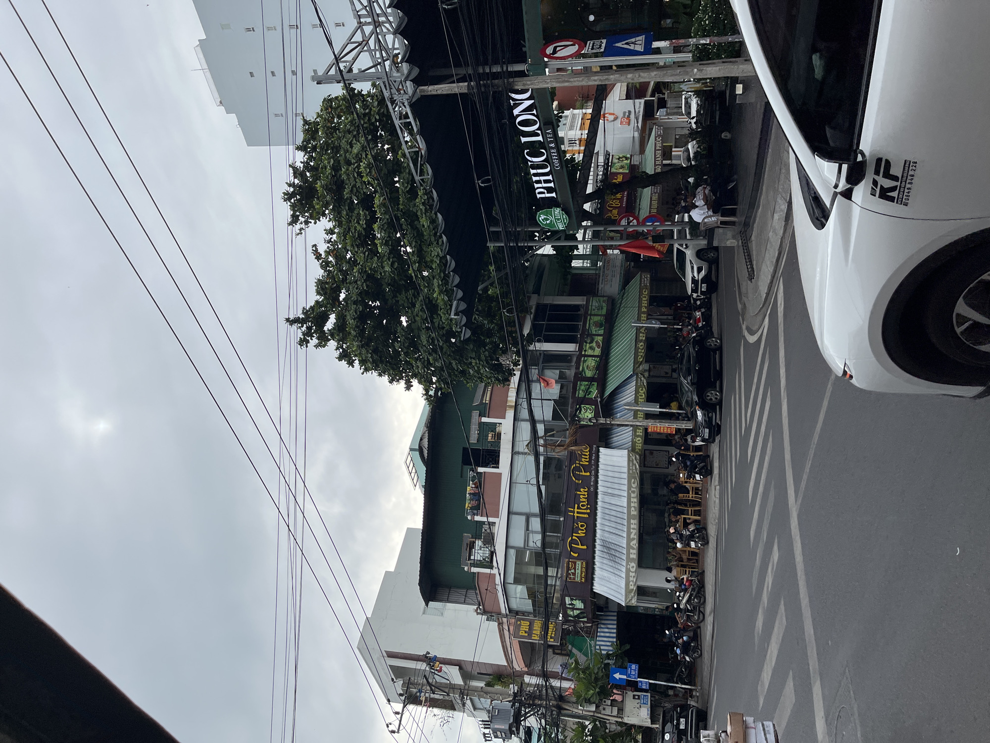 Nha Trang street life: traffic, storefronts, and a parked Porsche
