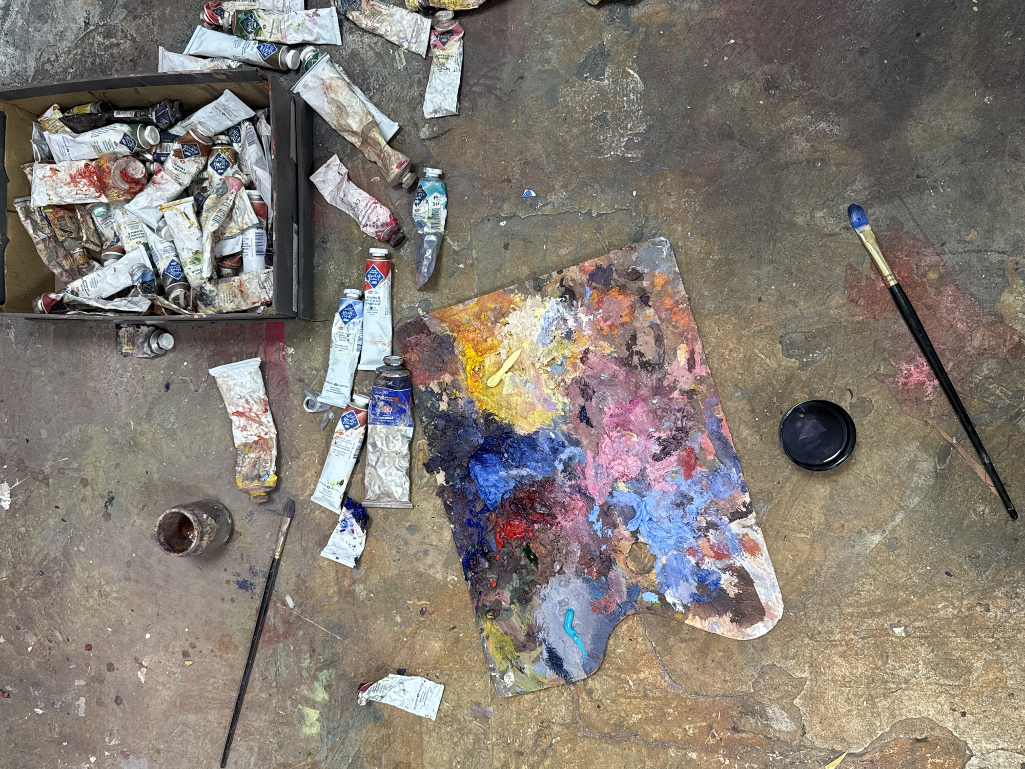 Artist's studio workspace documented with paintings and scattered supplies