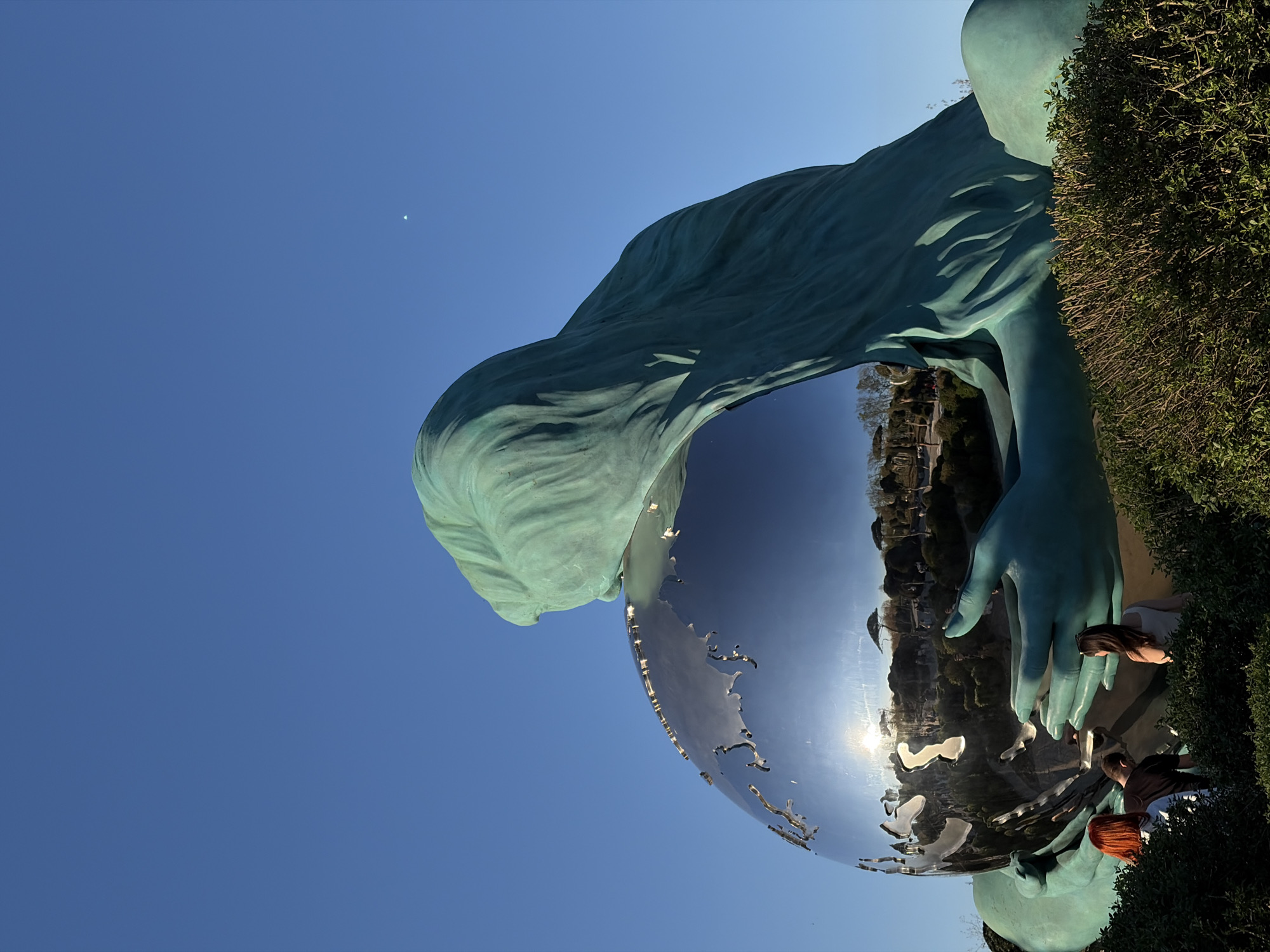 Krasnodar monument featuring woman holding globe photographed by visitors
