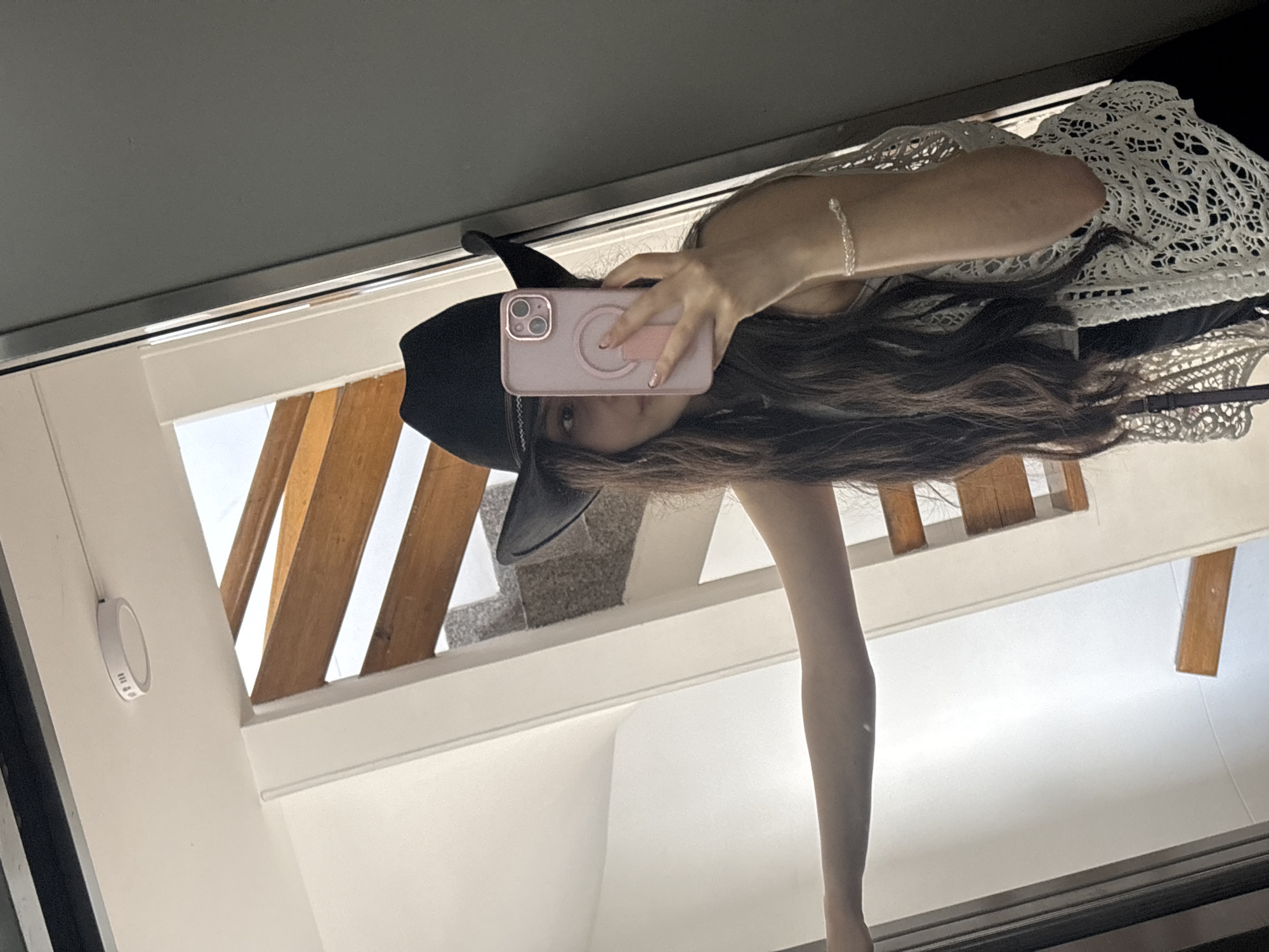 Woman takes mirror selfie in Medellín building interior