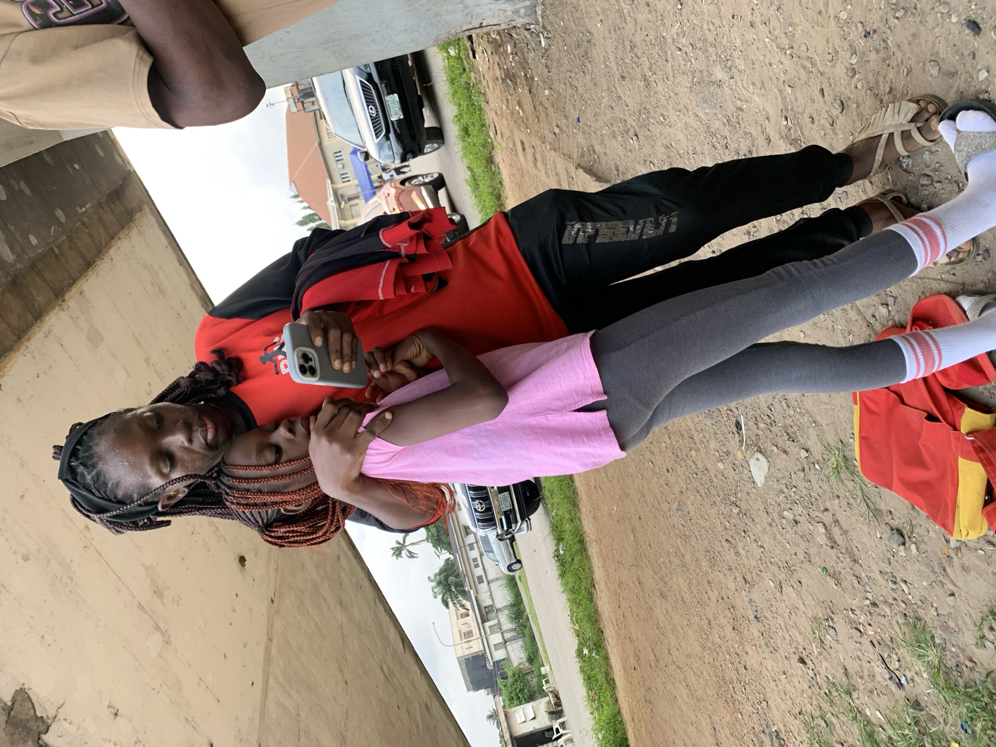 BMX riders throwing tricks on a paved court in Alagbede