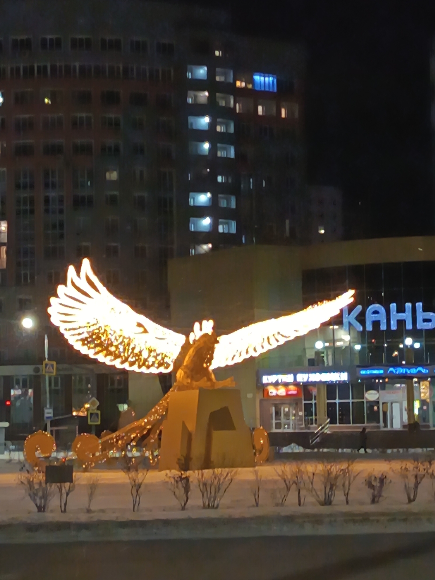 Illuminated griffin monument observed during Nizhnevartovsk winter night
