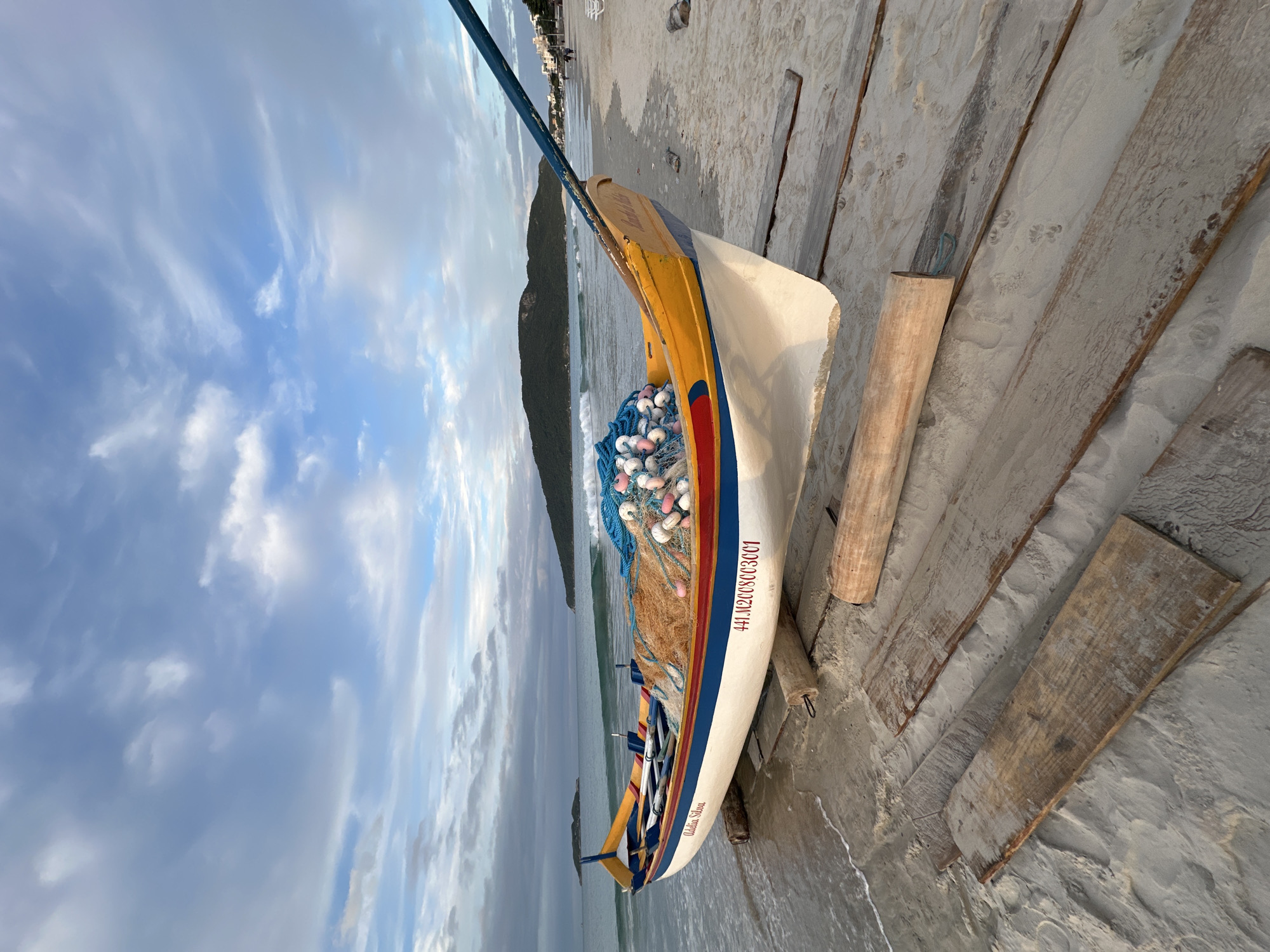 Beach life captured: fishing boat and family stroll in Florianópolis