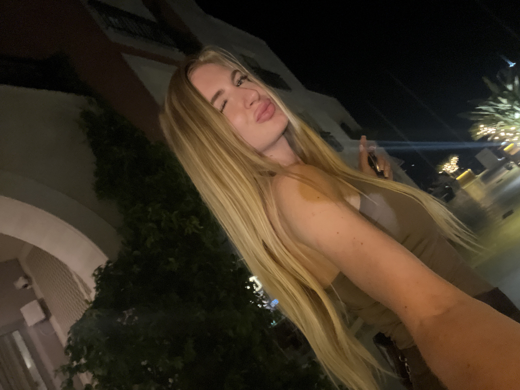 Woman makes playful expressions outdoors in Tivat at night