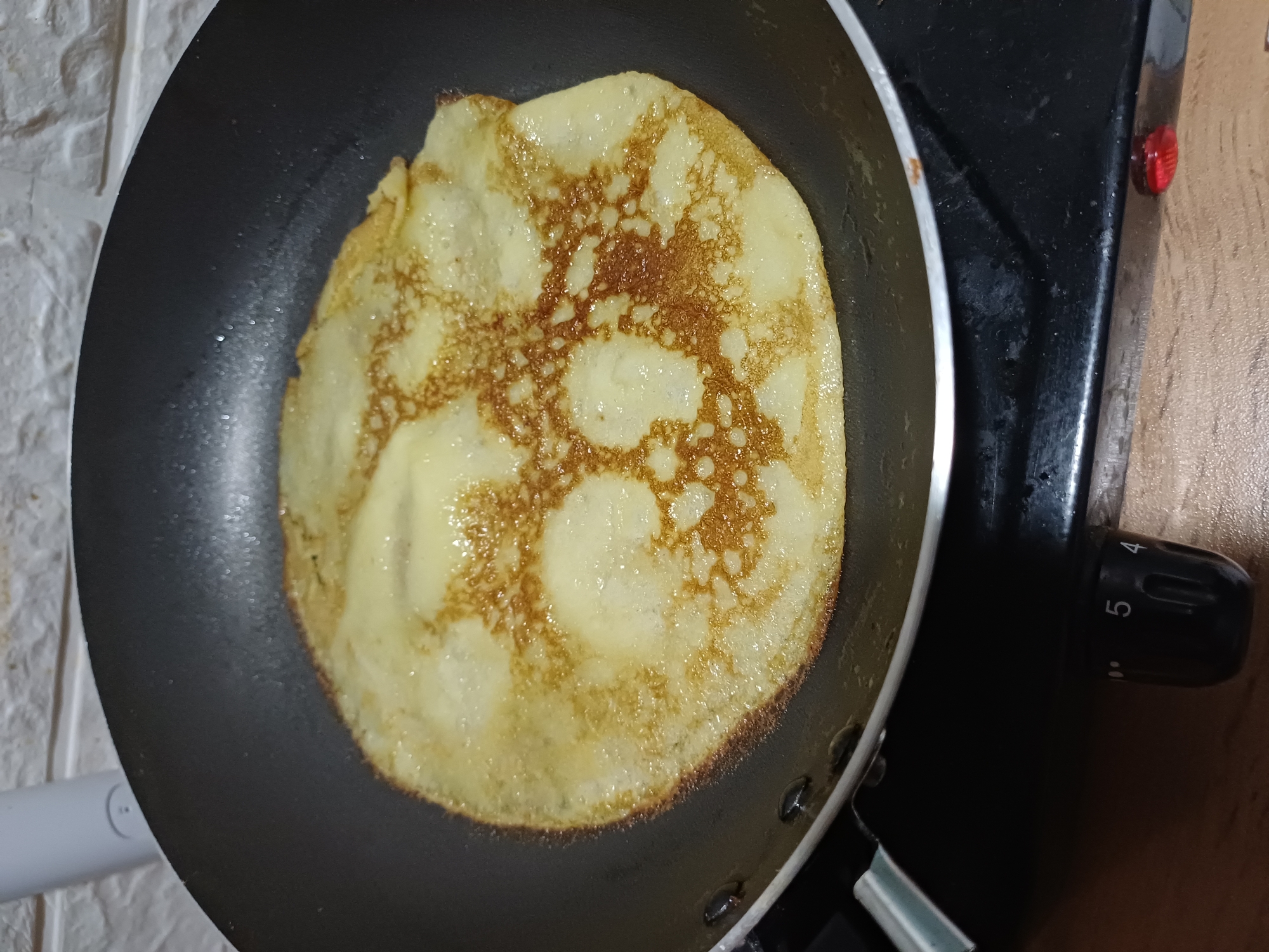 Homemade crepes cooking on a Sochi kitchen stovetop