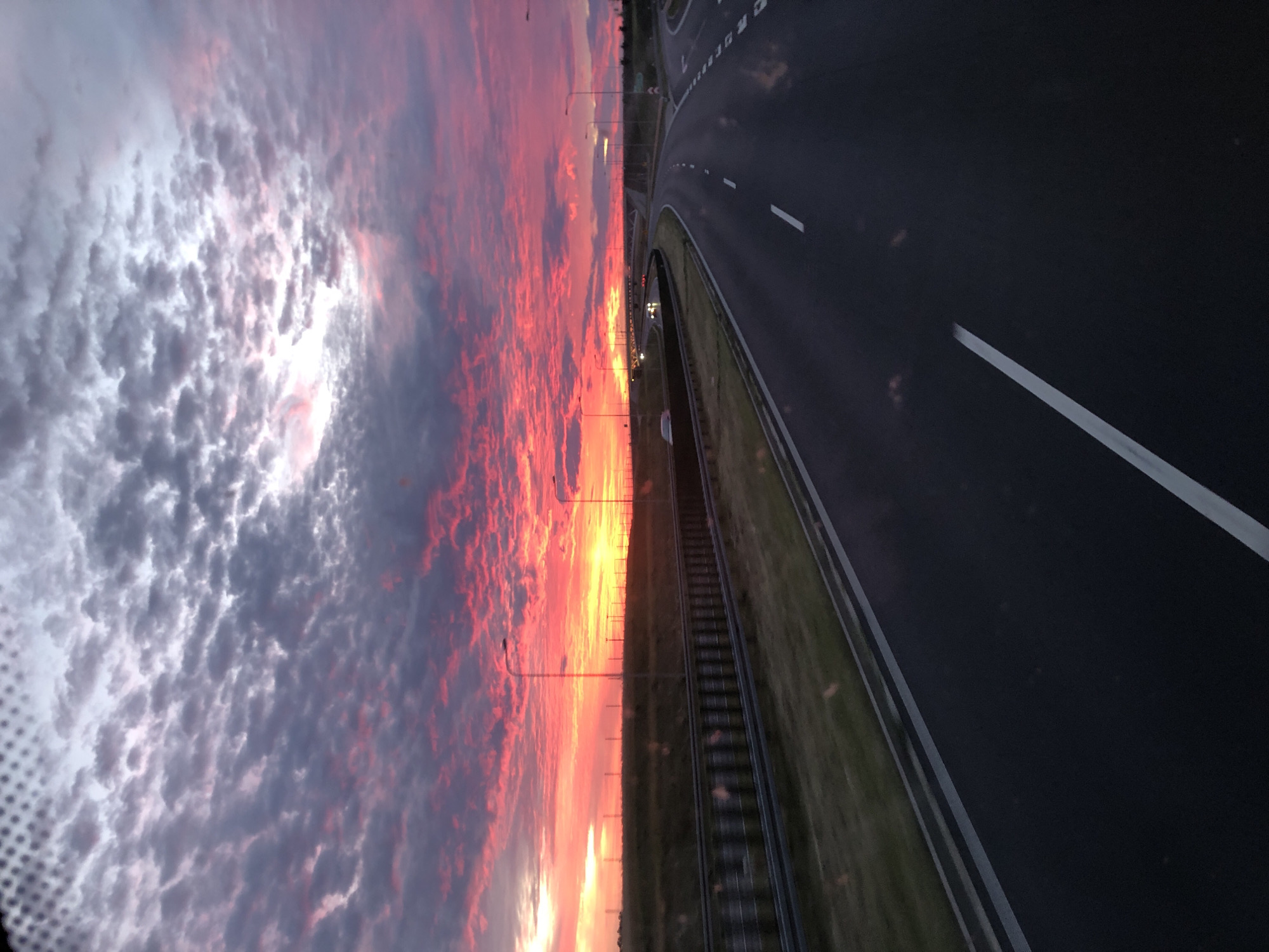 Vivid sunset over a Polish highway, early evening.
