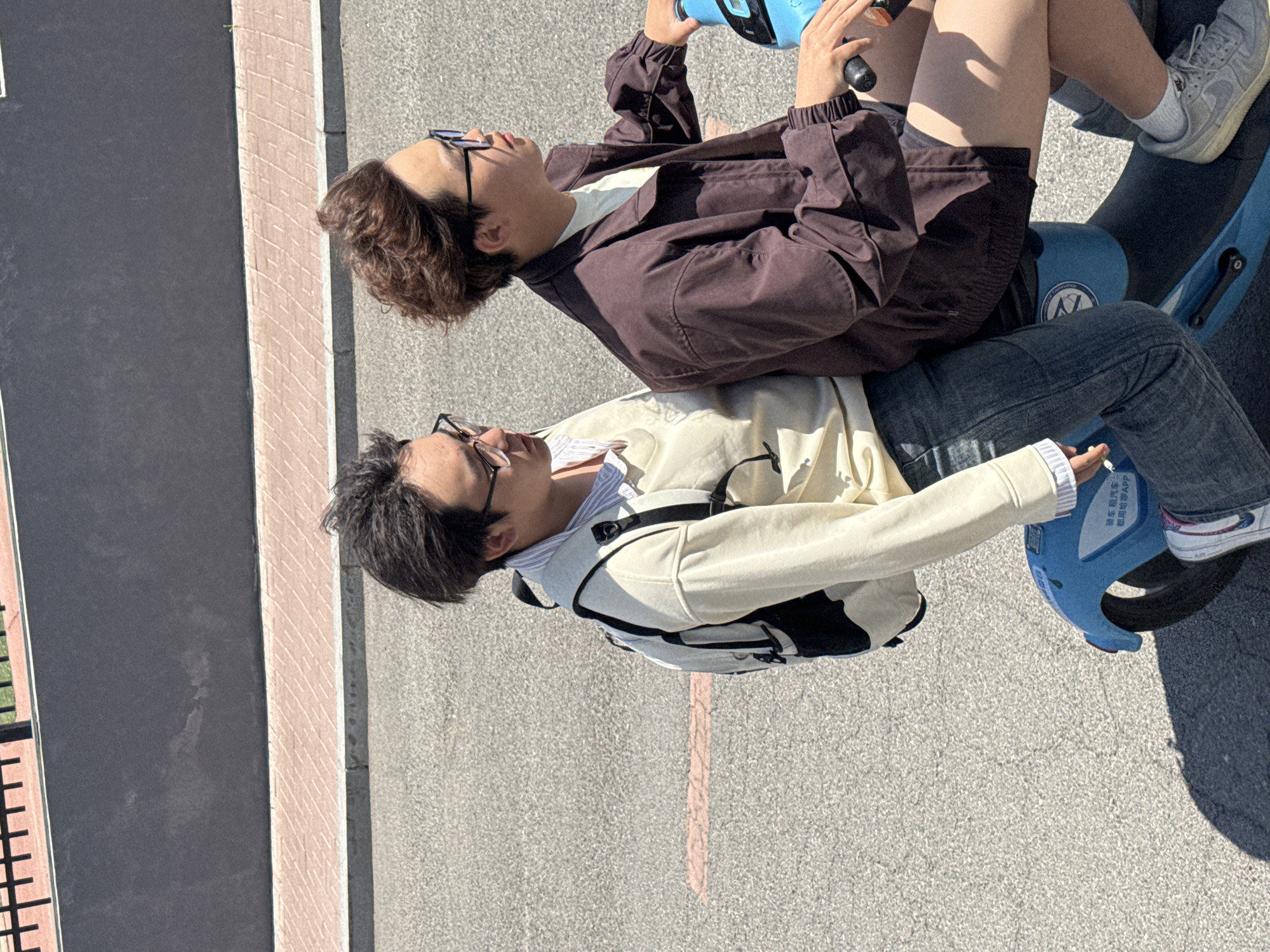 Young people ride shared scooters in sunny Zhongtun morning