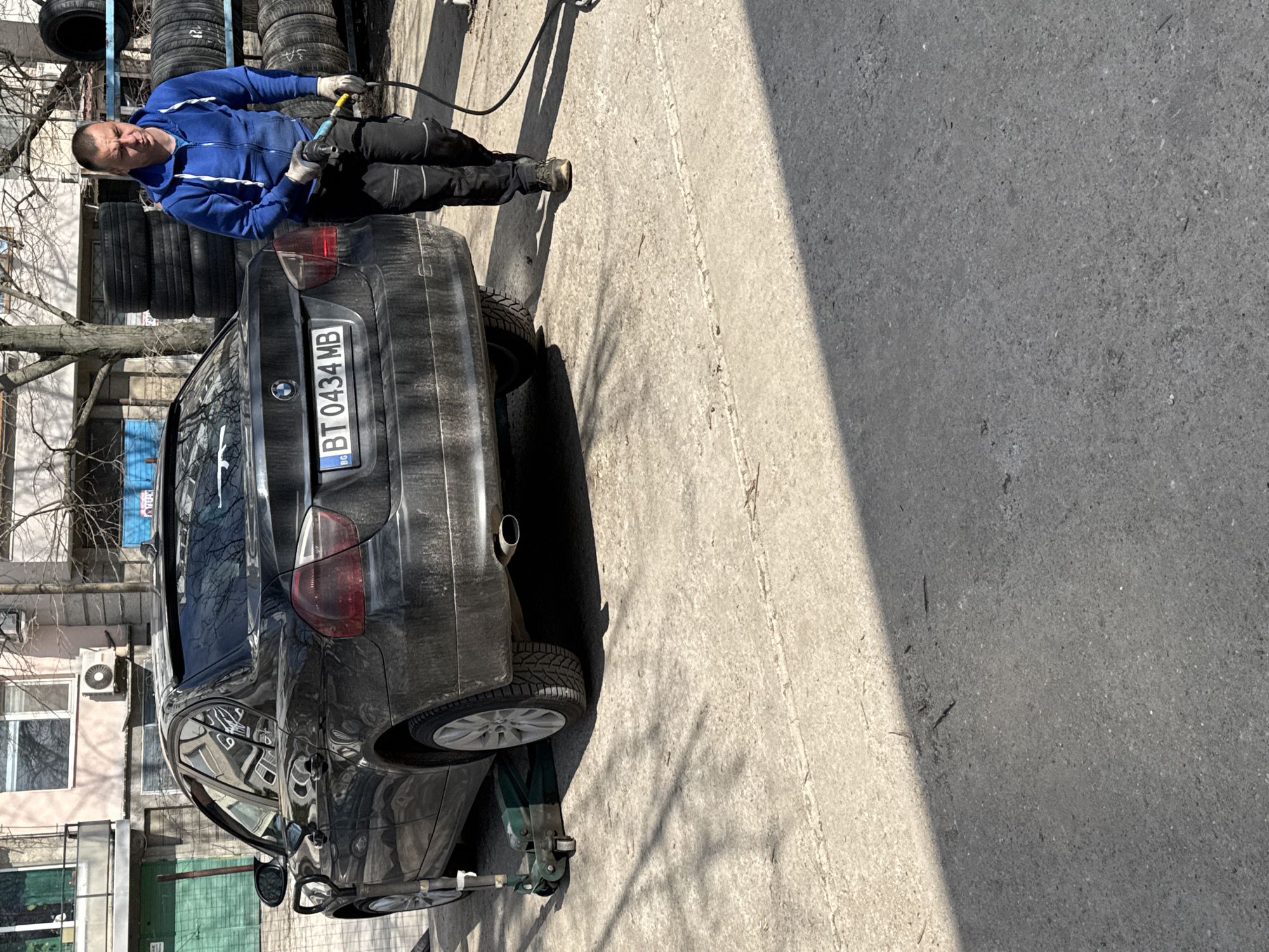 Man inflates BMW tire in Ruse, Bulgaria