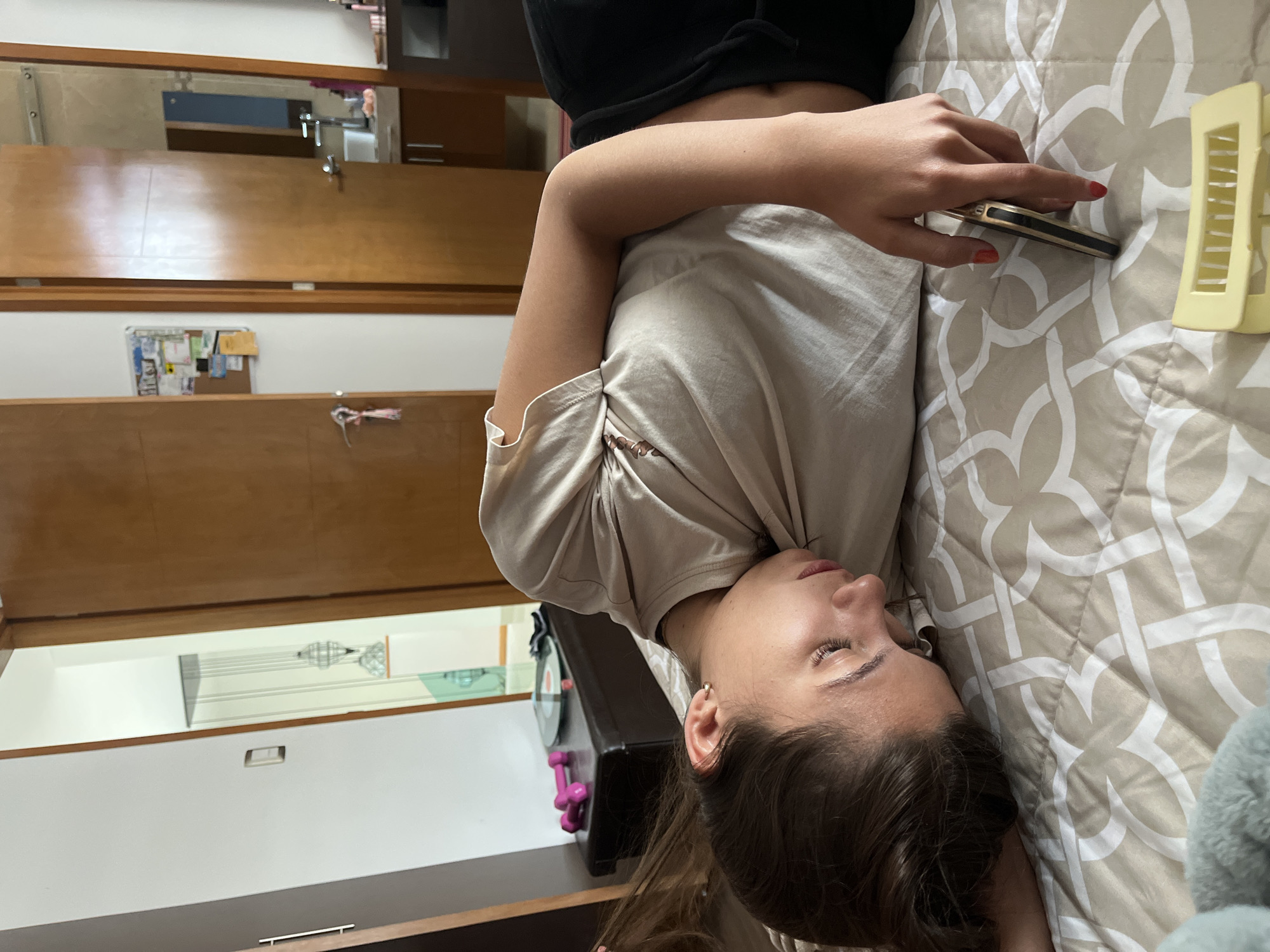 Woman uses smartphone while resting on bed in Mexico