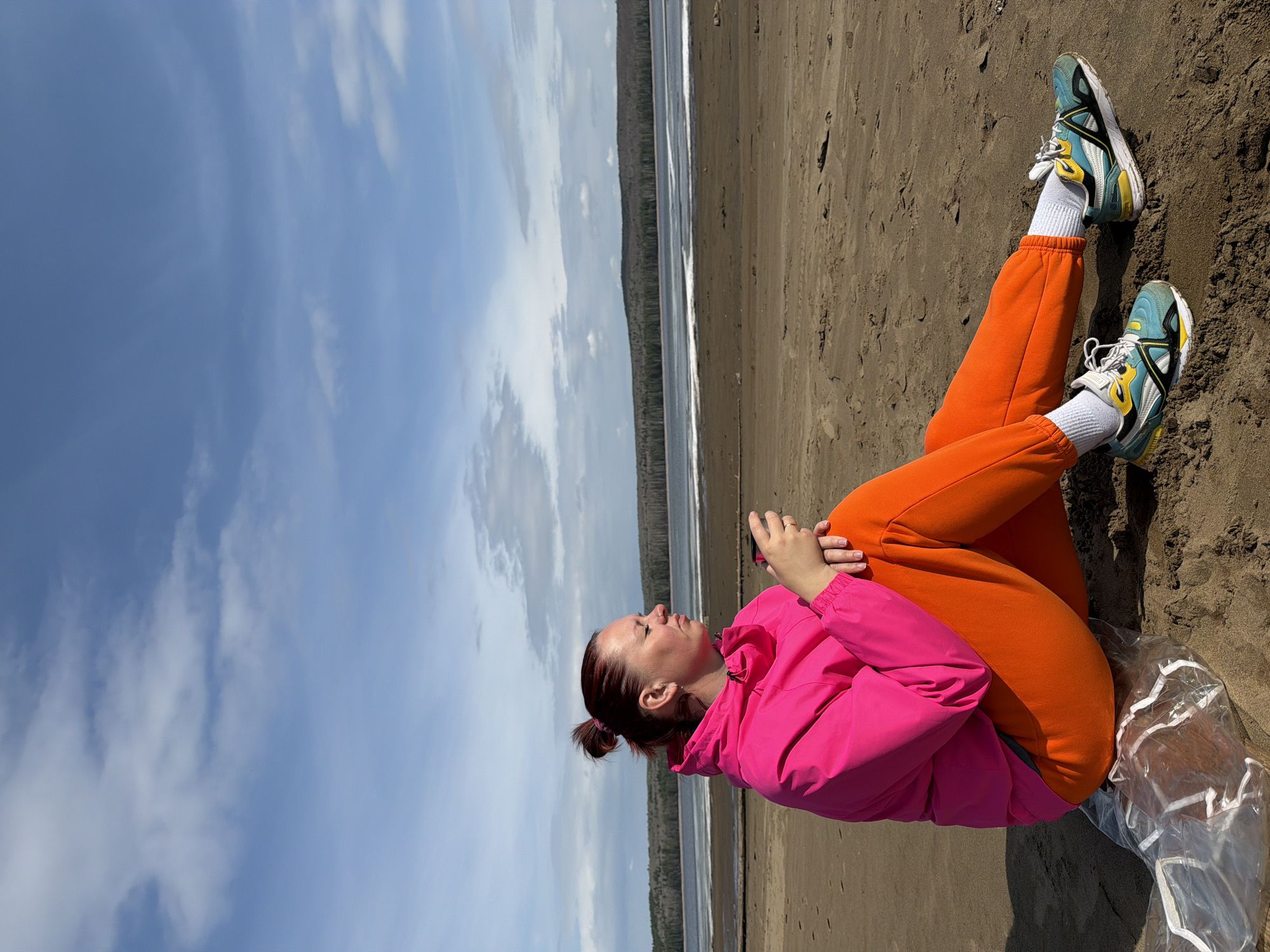 Woman enjoys sunny morning at Chaikovsky beach amid forest landscape