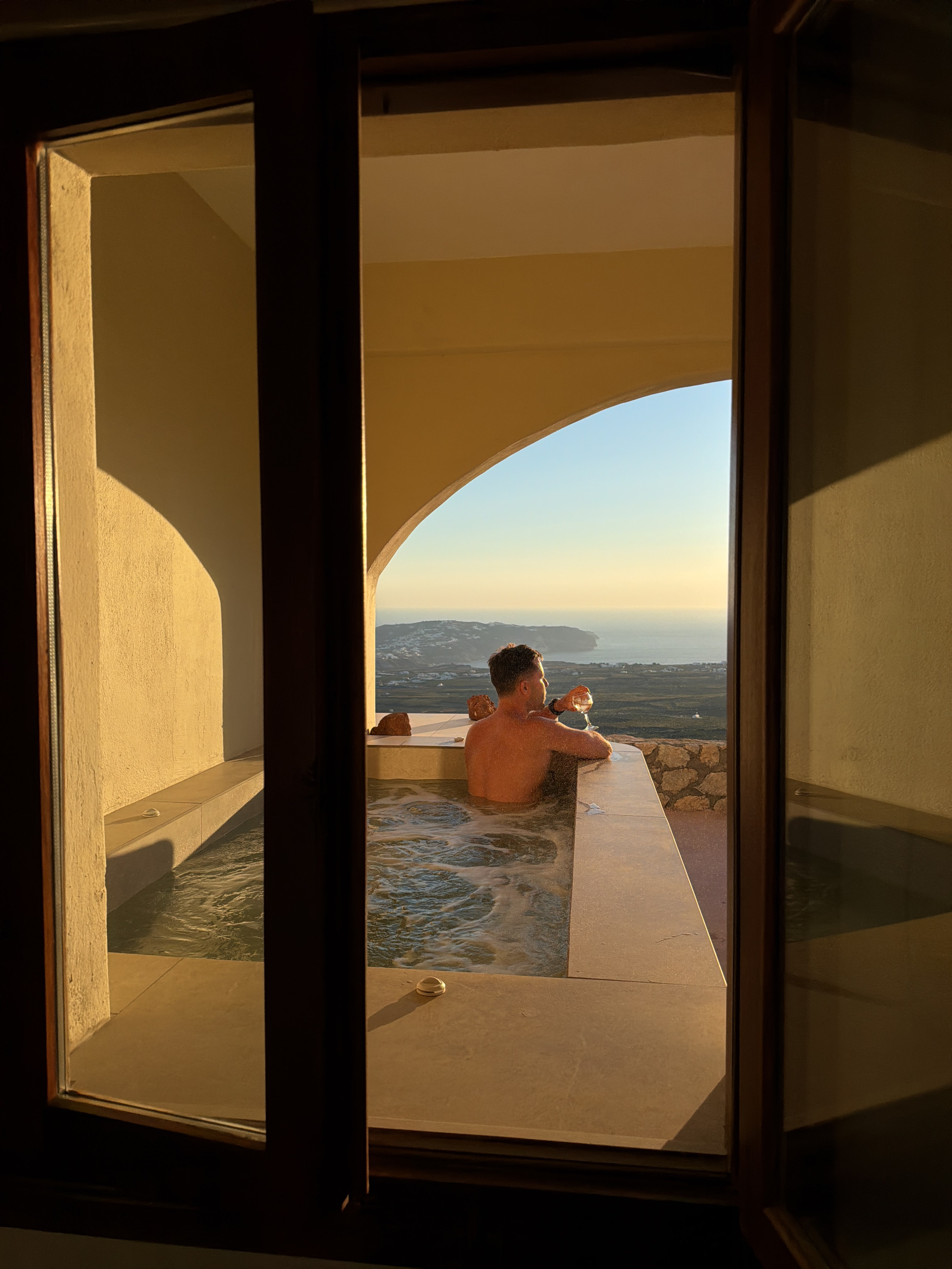 Champagne in a Santorini cliffside hot tub, caldera views