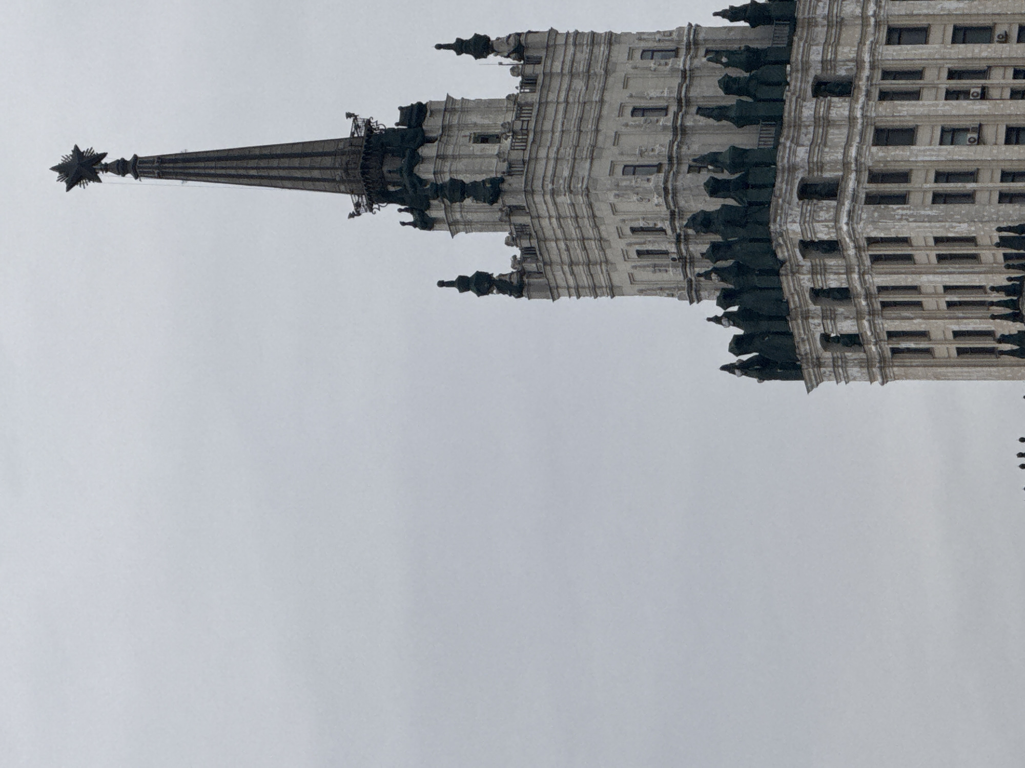 Moscow Stalinist skyscraper with Soviet star photographed under grey sky