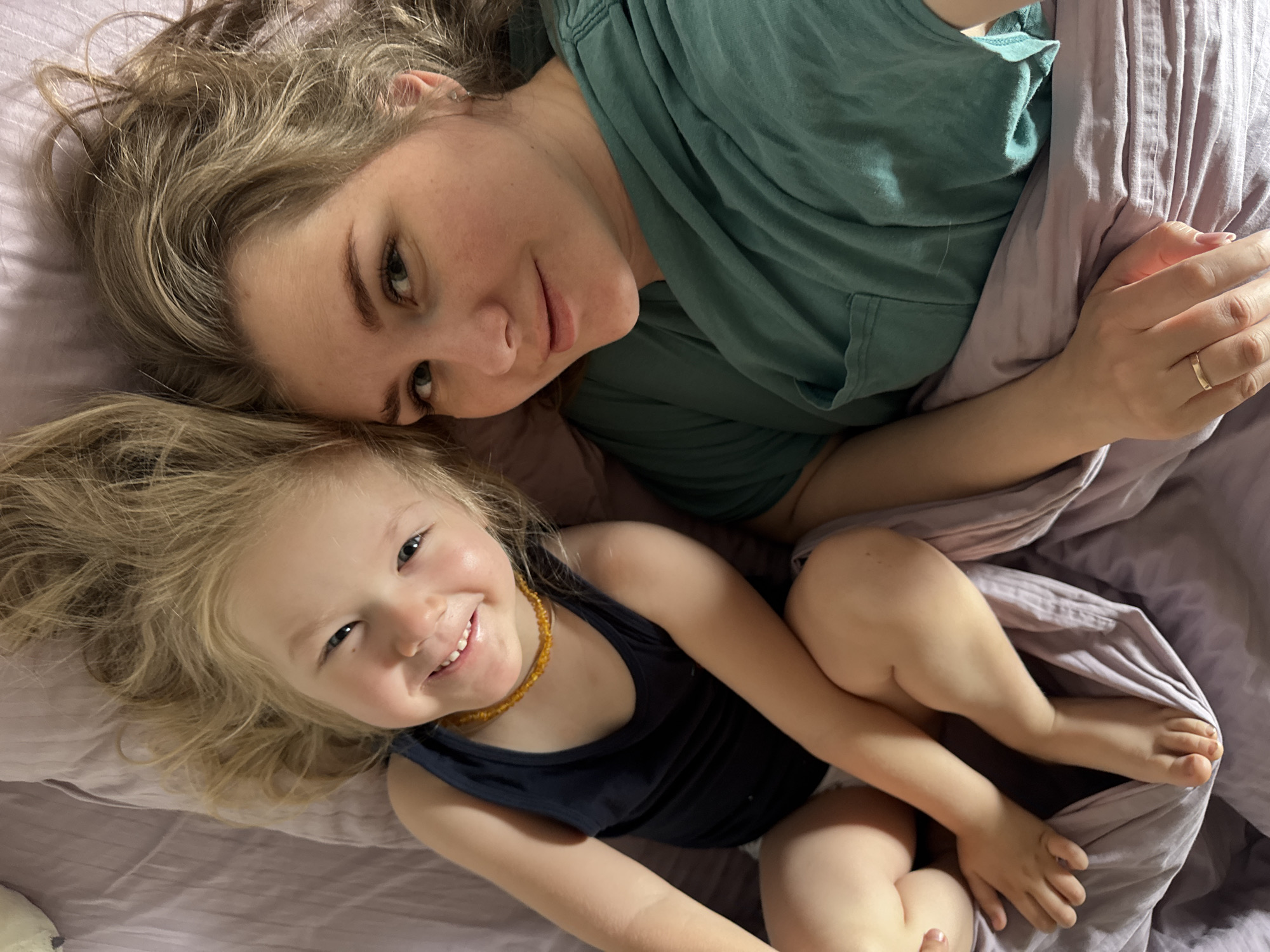Mother and child share quiet morning moment on bed