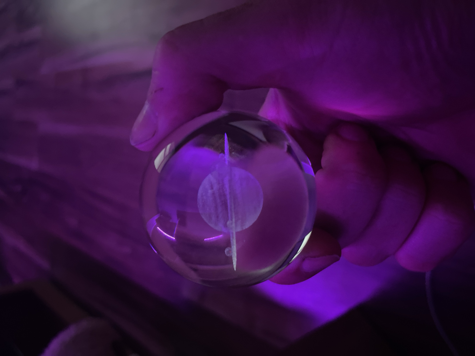 Saturn-etched glass orb under purple light, Gliwice