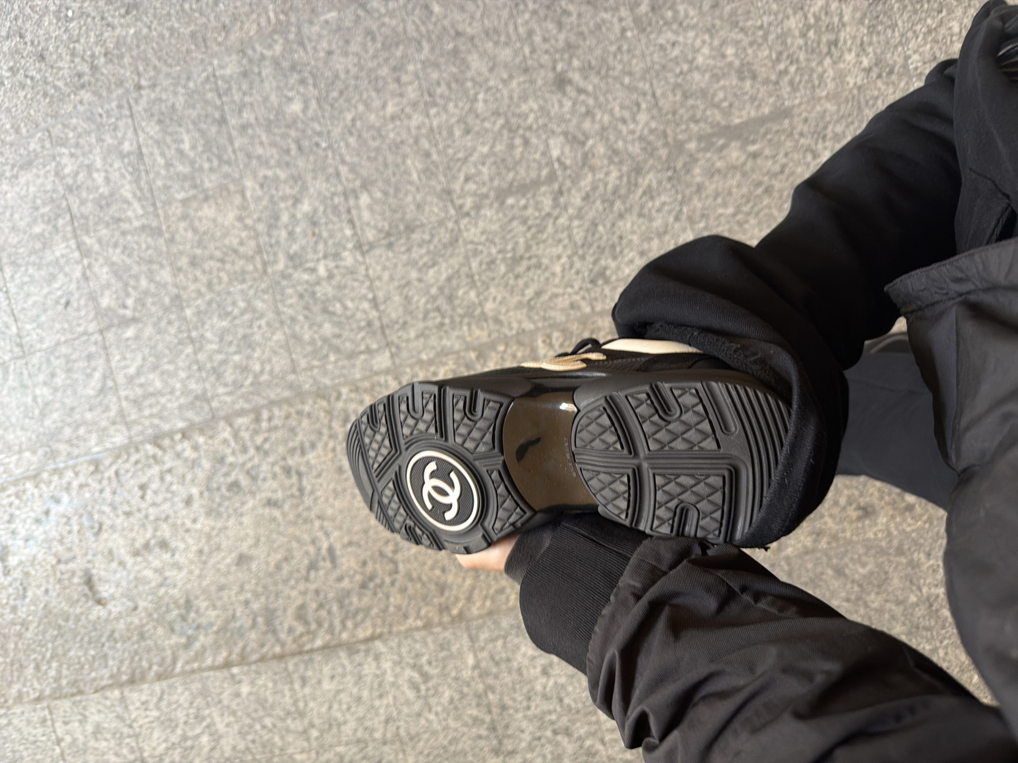 Person displays Chanel sneaker sole on Milan pavement