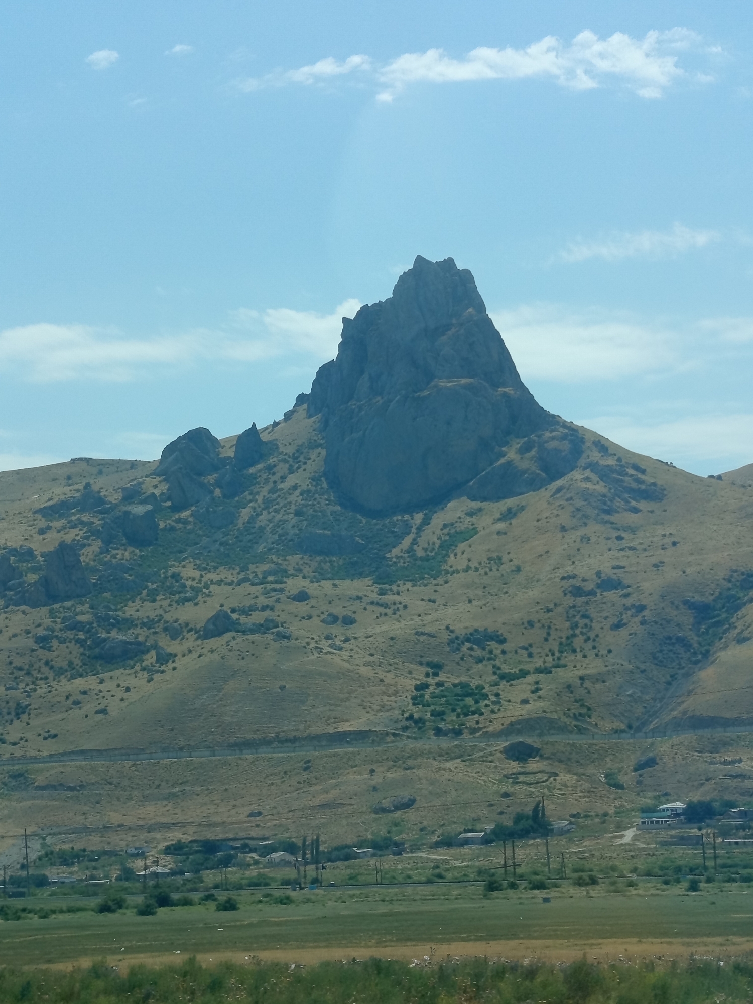 Jagged peak cuts into clear skies over Azerbaijan's mountain terrain