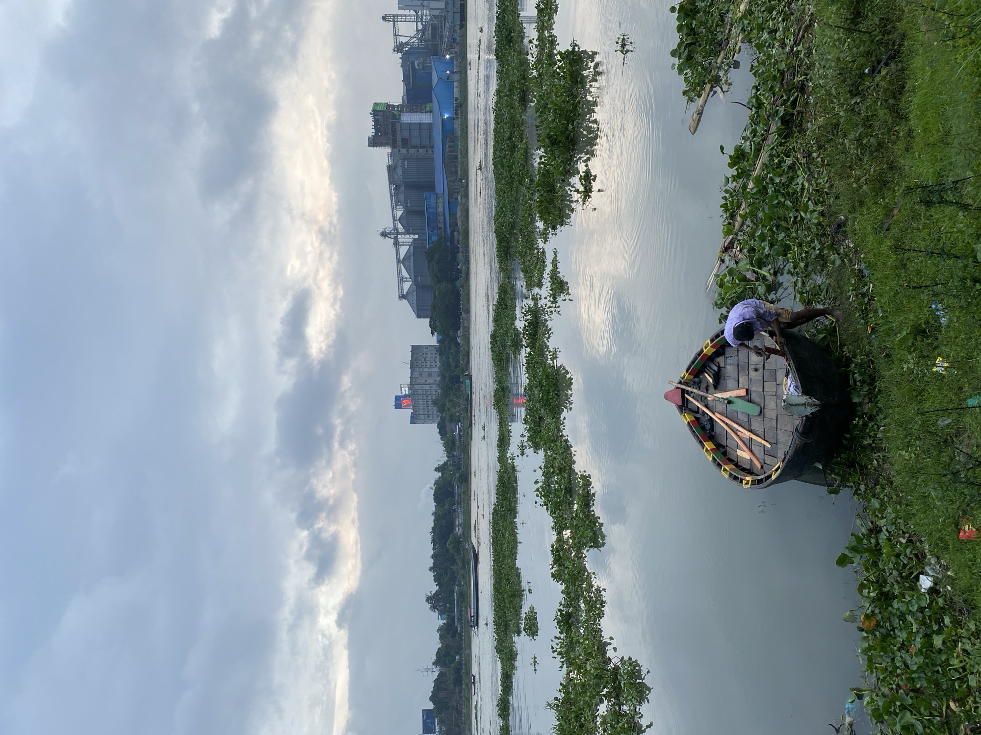 Buriganga River life: boats, flowers, and industrial infrastructure