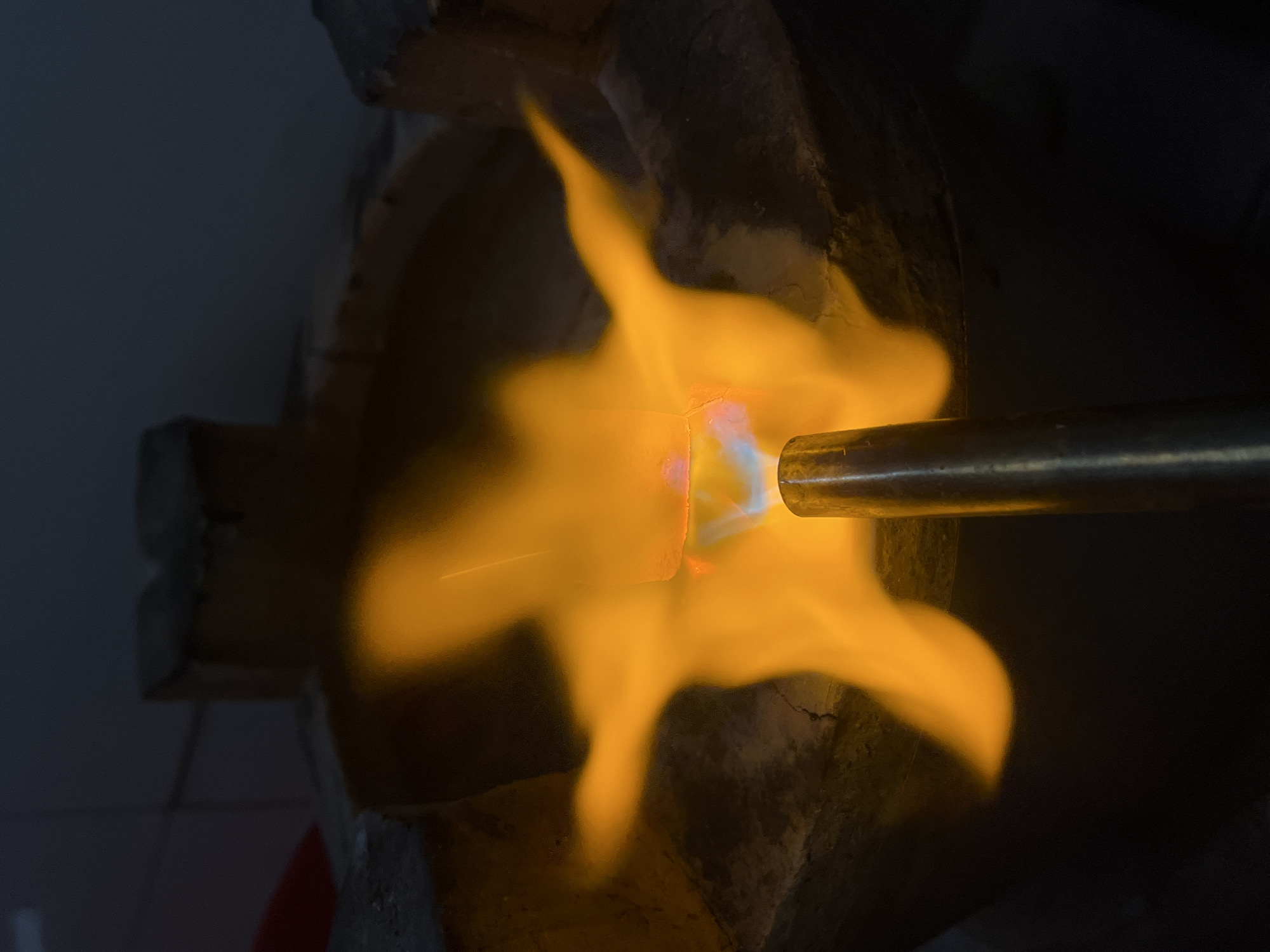 Torch work fusing metal in a Nha Trang clay stove setup