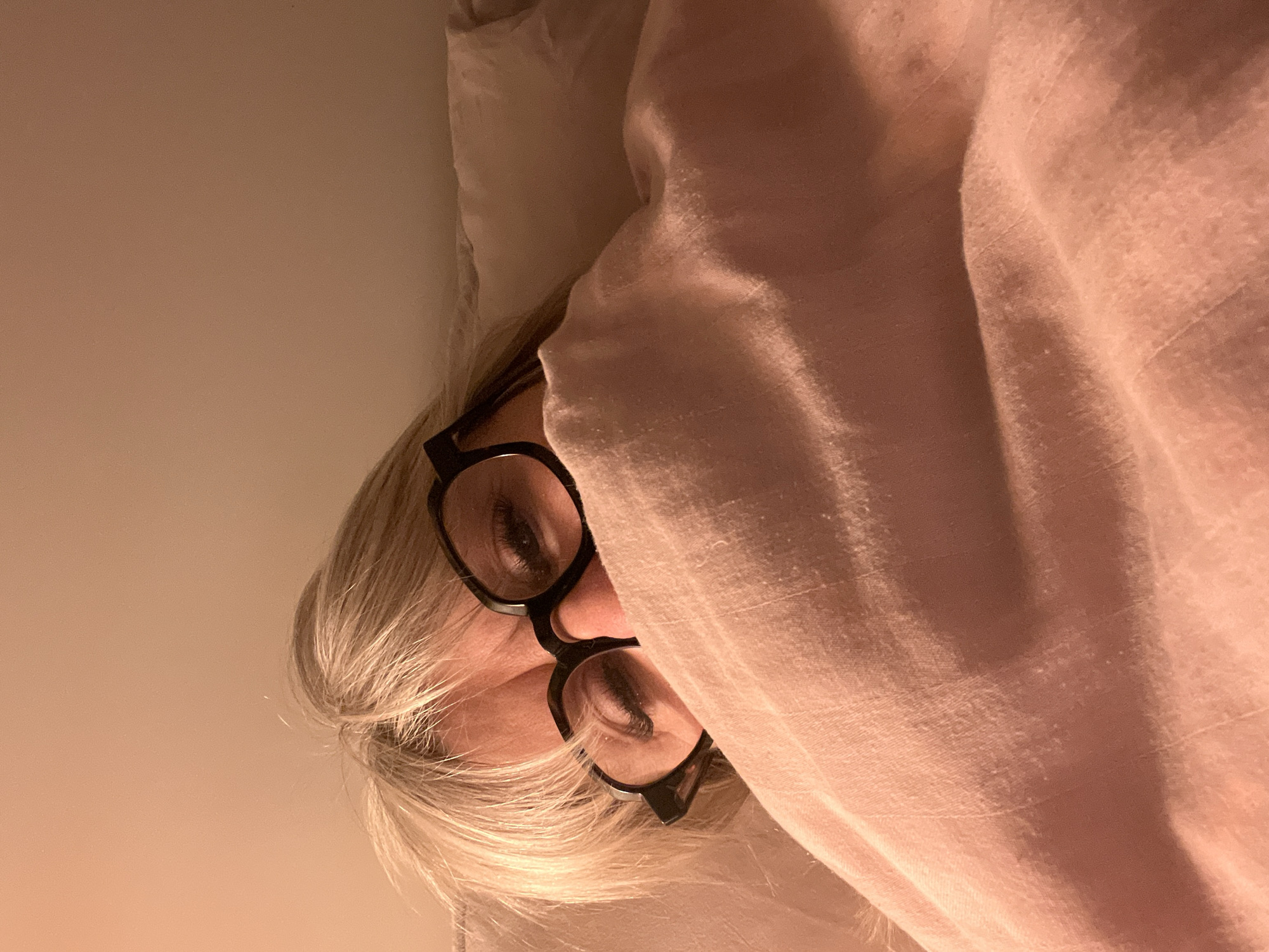 Person peers from pink blanket indoors in Chambœuf