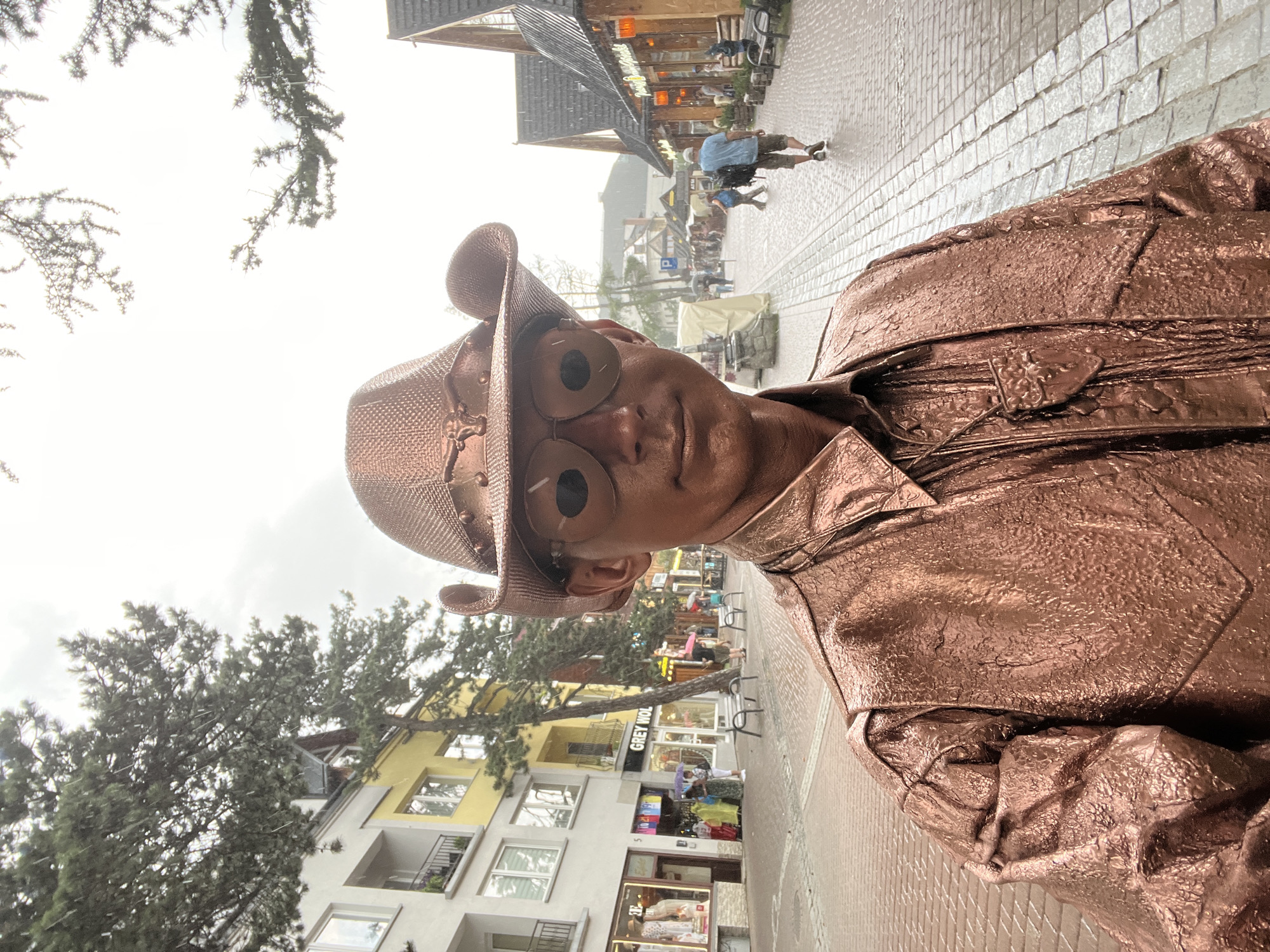 Bronze cowboy street performer works Zakopane's rainy cobblestones