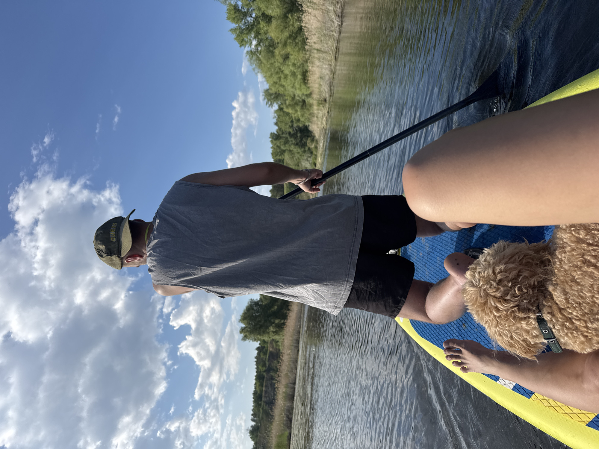 Paddleboarders with dog enjoy afternoon outing near Pribrezhnyi