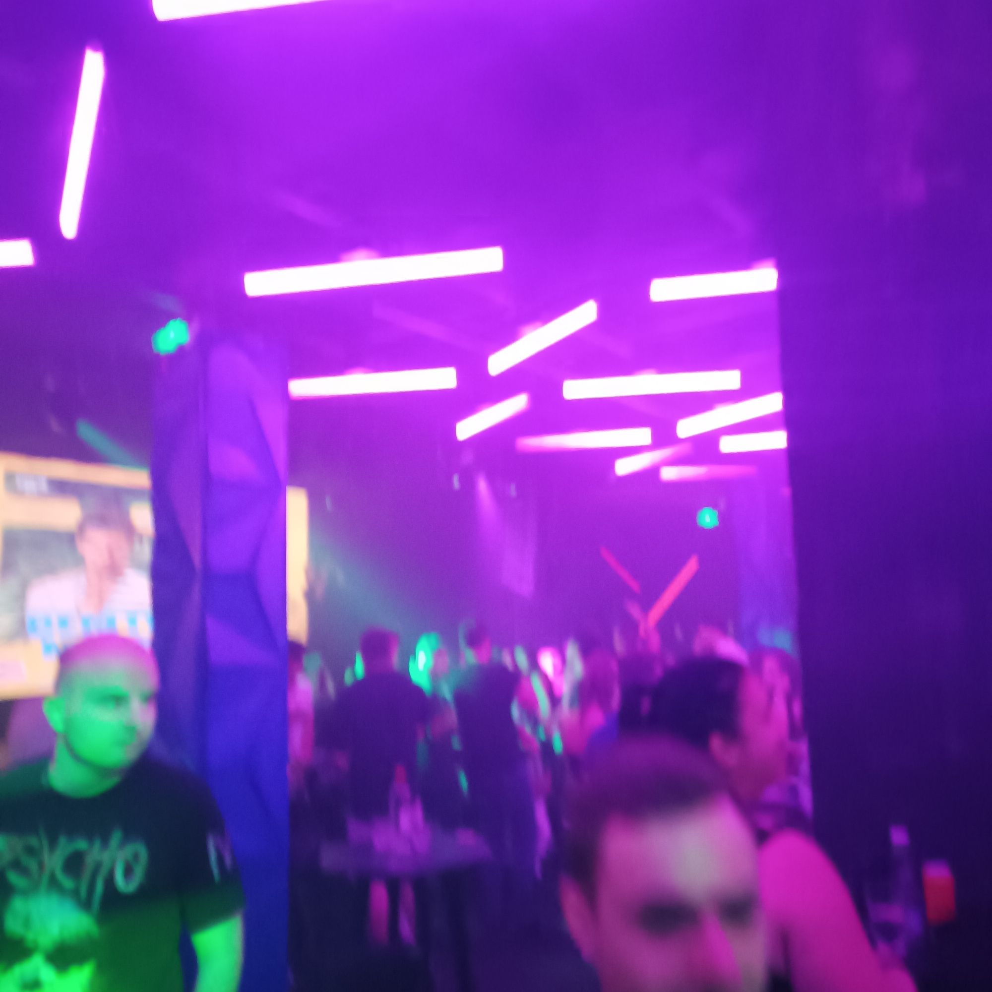 DJs perform at club with FOMO signage, patrons dance