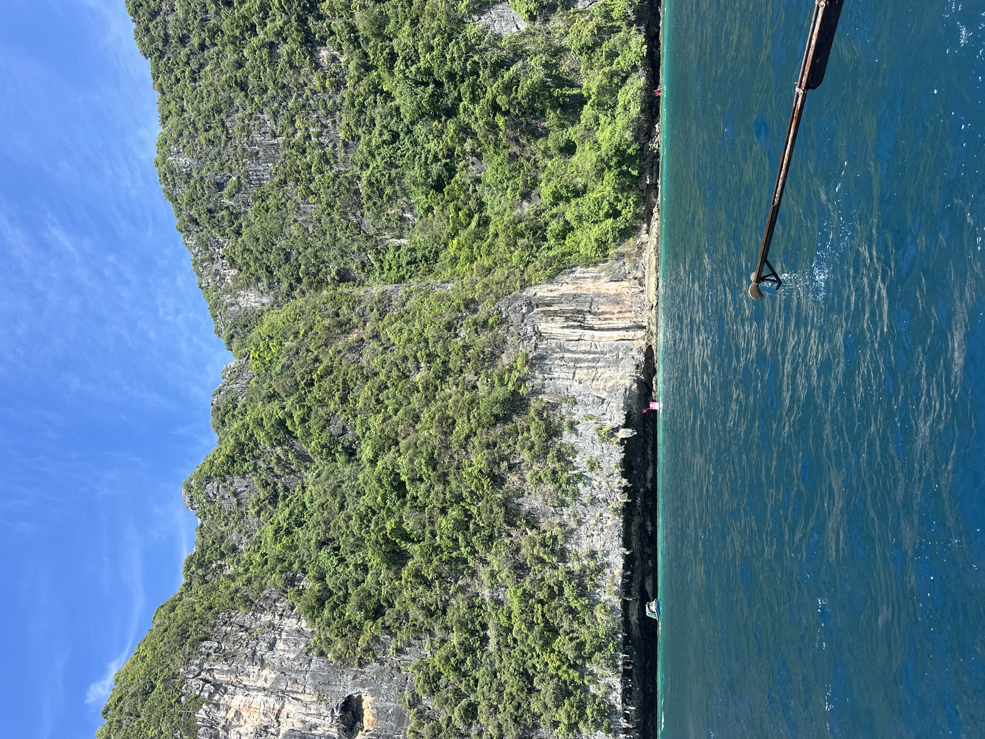 Longtail boat navigates limestone karsts off Haad Yao