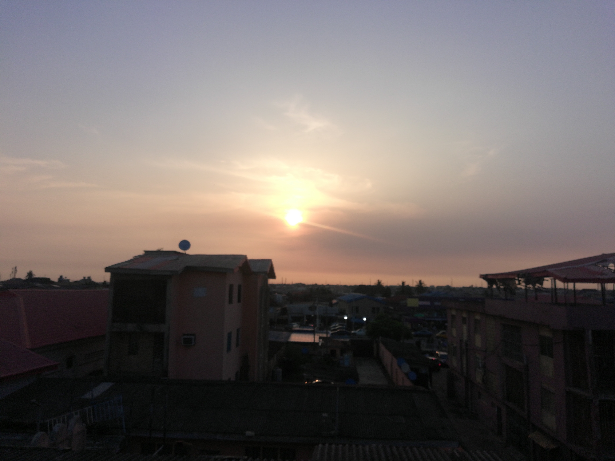 Sunset observed over Lagos cityscape amid cloudy skies