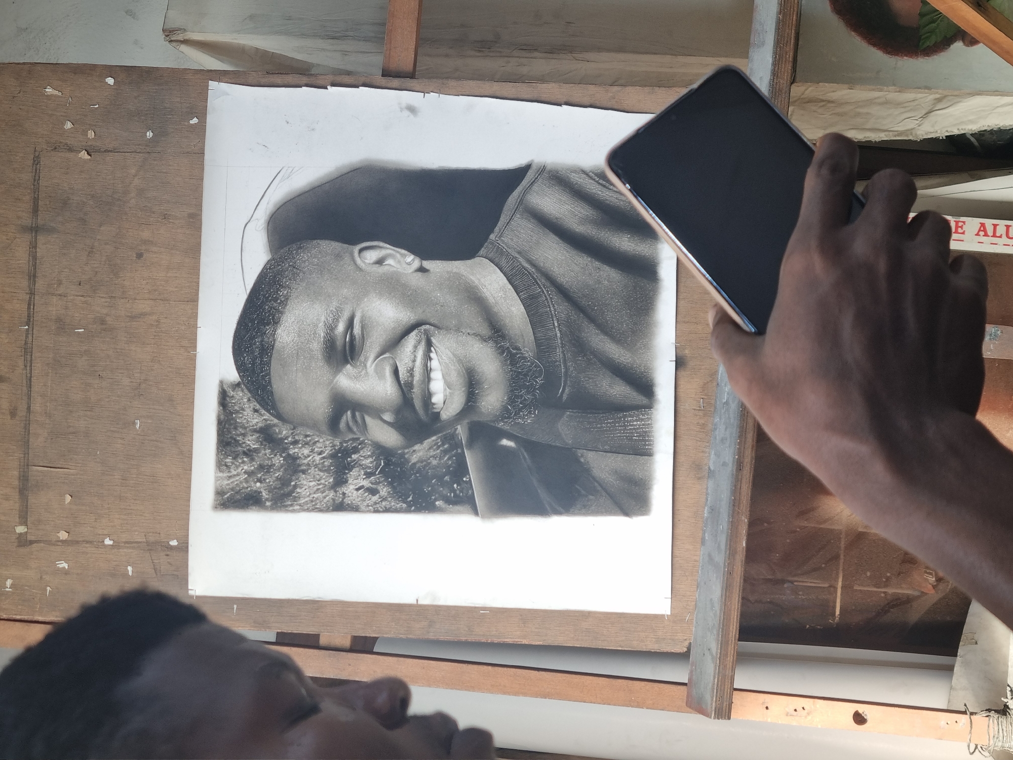 Street artist creates charcoal portraits in Onitsha, Nigeria