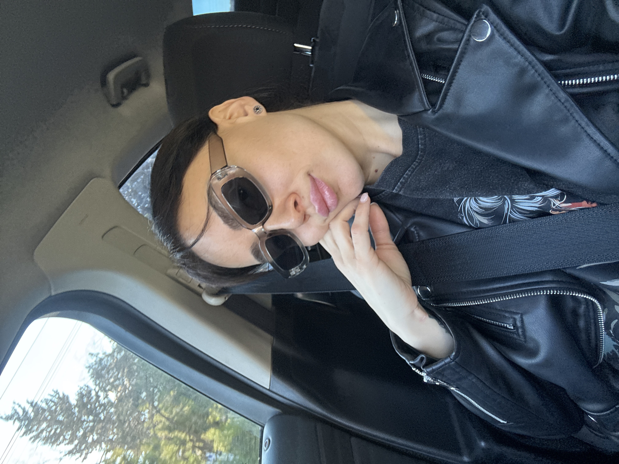 Woman in sunglasses sits in car in Tbilisi