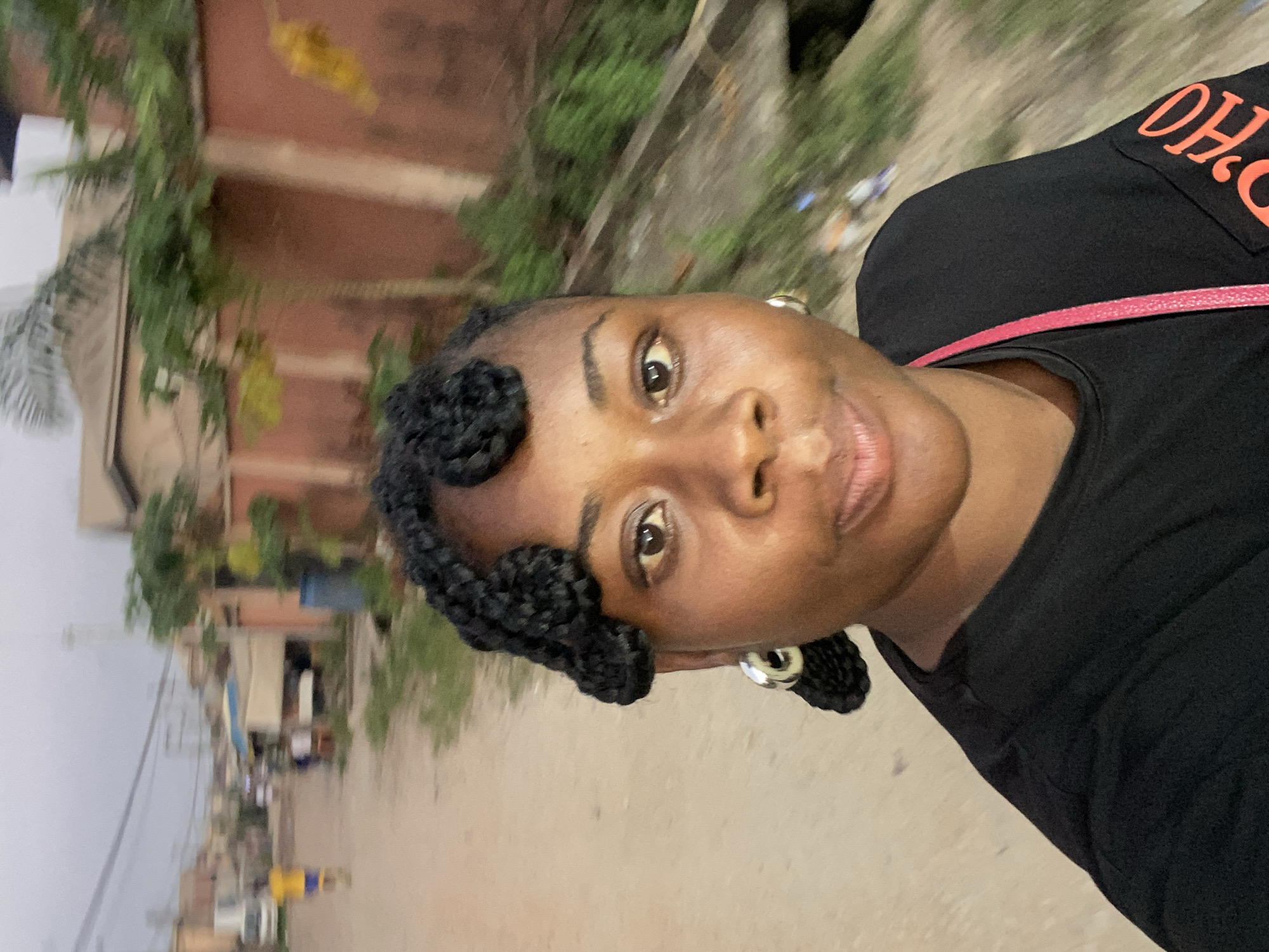 Woman takes selfie on unpaved Lagos street at dusk