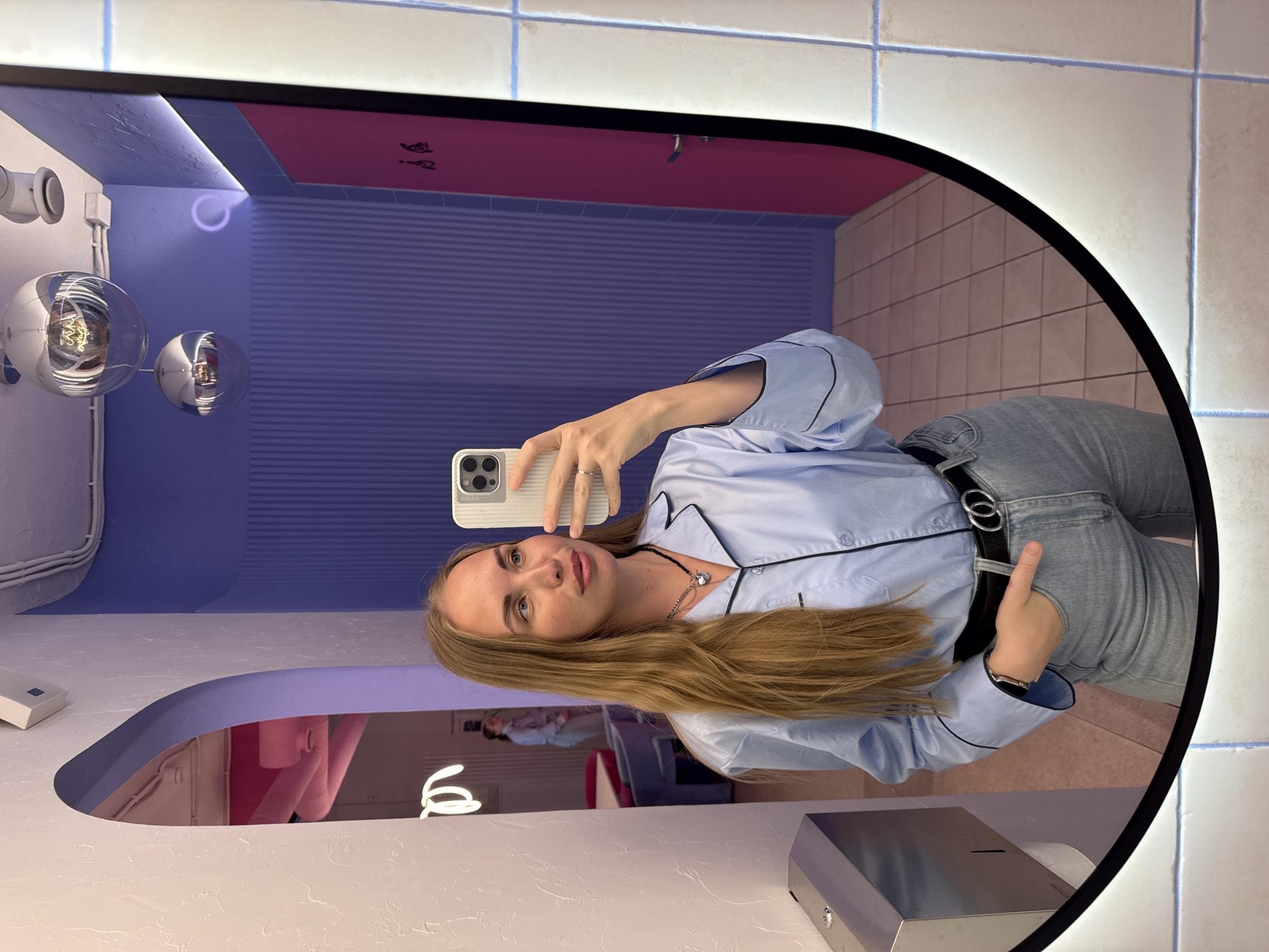 Woman takes mirror selfies in pink-themed Sochi restroom