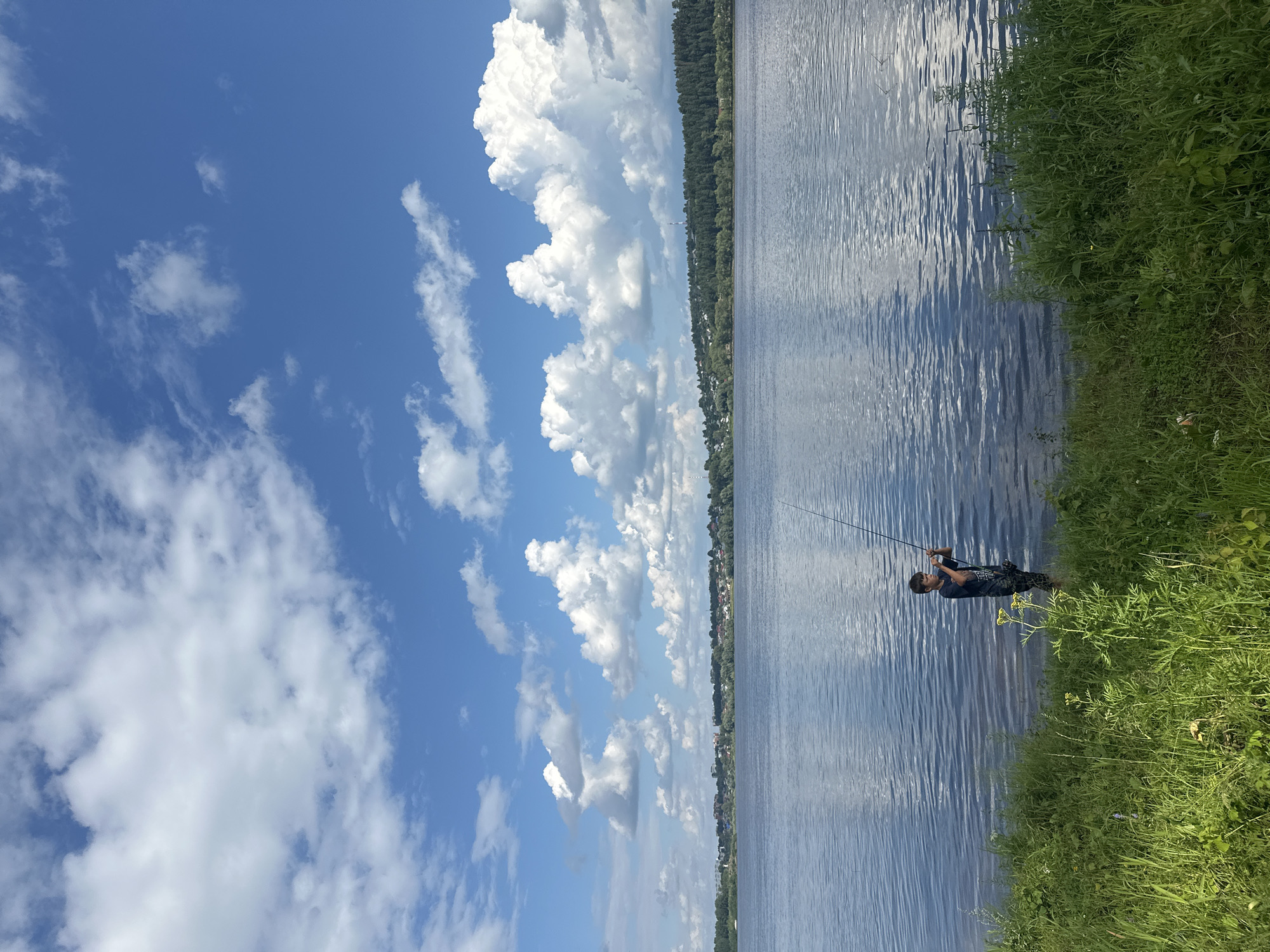 Fishing in the Volga shallows, forested hills across the river