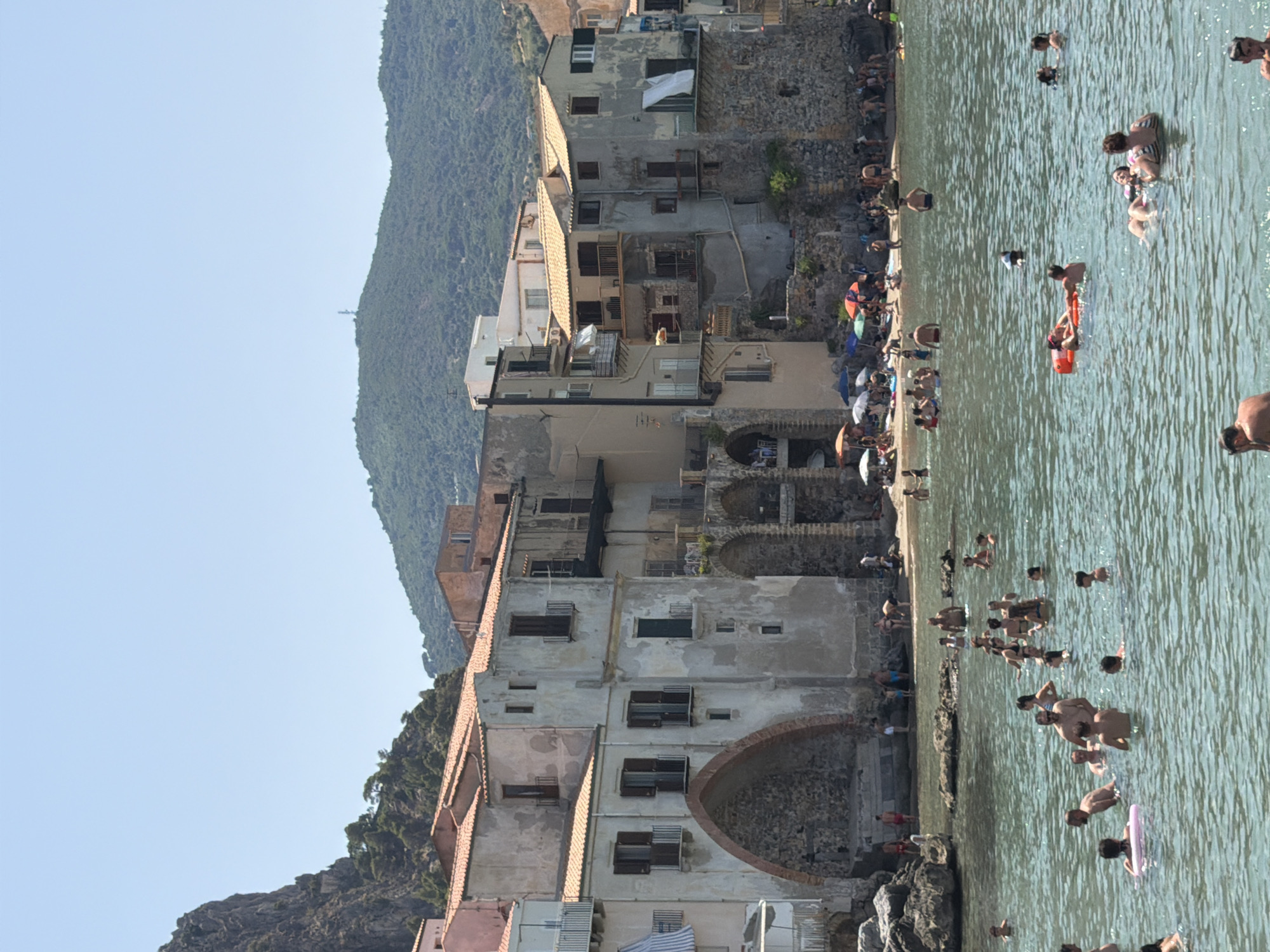 Cefalù beach in full summer swing, umbrellas and medieval backdrop