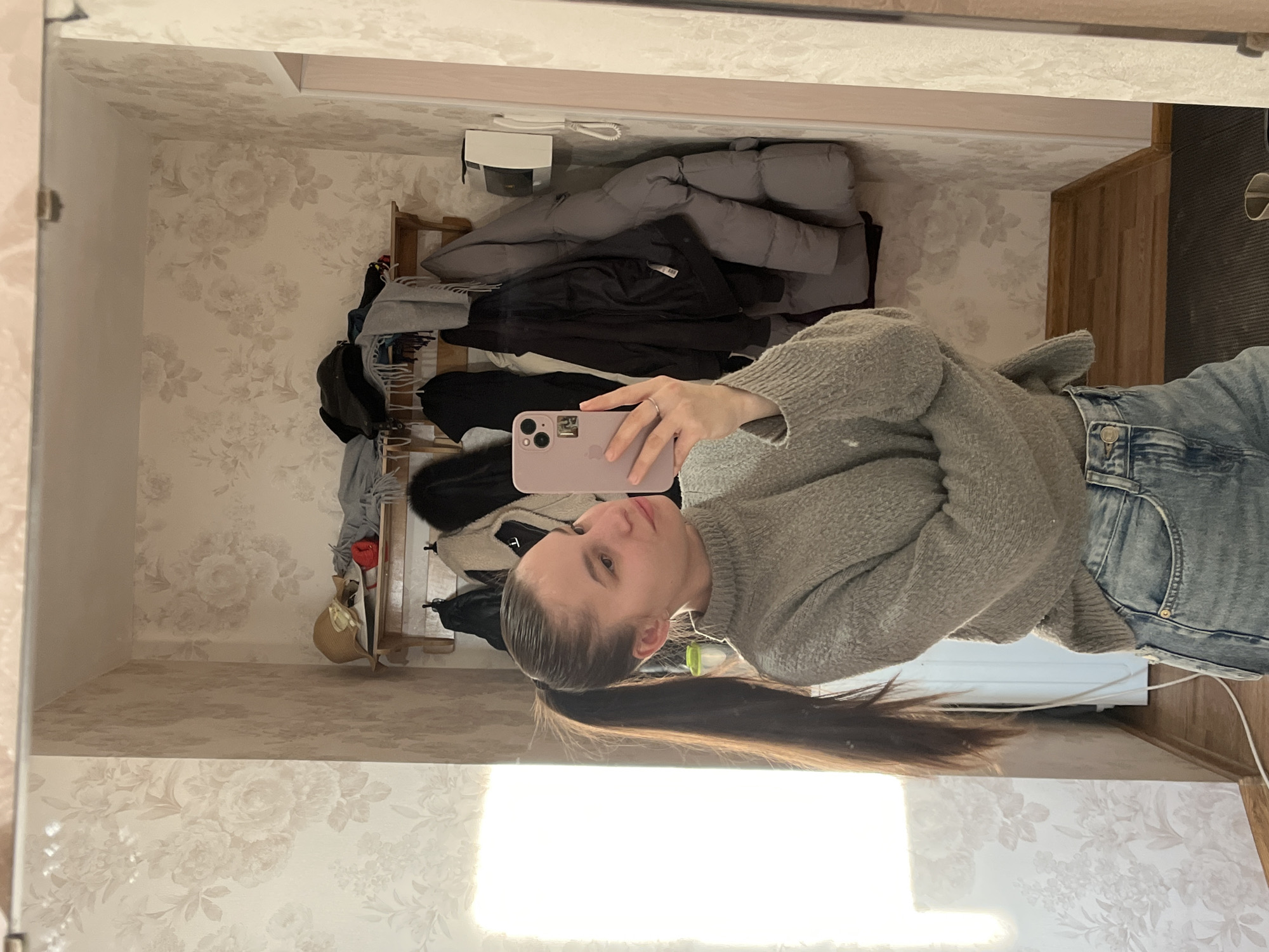 Woman takes selfie in floral wallpapered room in Chaikovsky