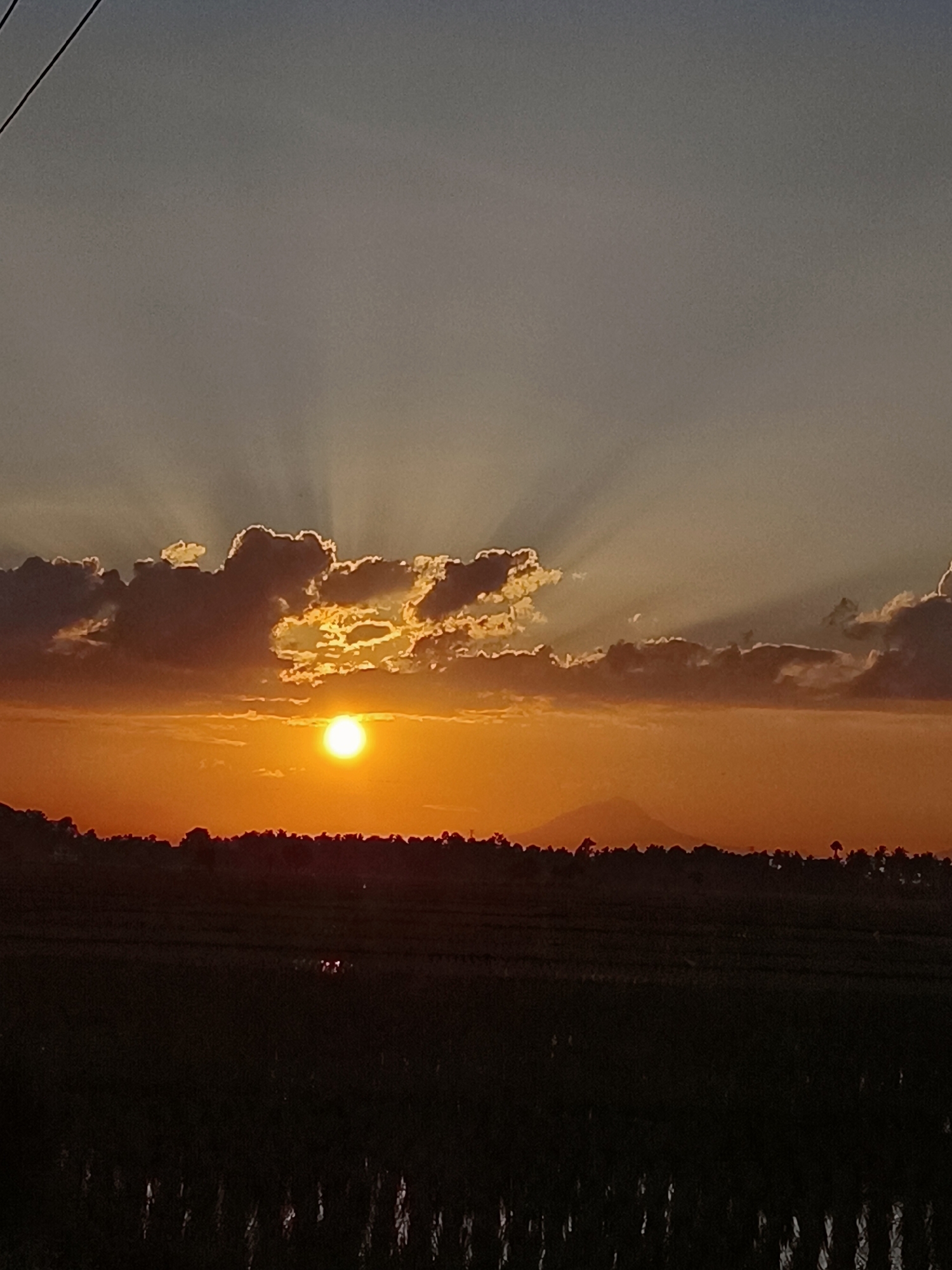 Sunset over rural Indonesia, clouds and orange light