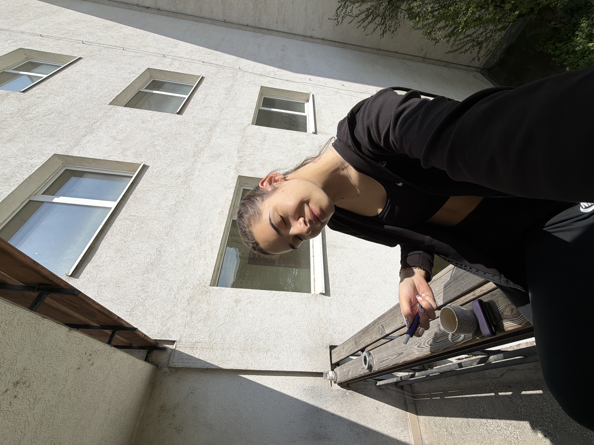 Woman writes with coffee on Sofia balcony morning