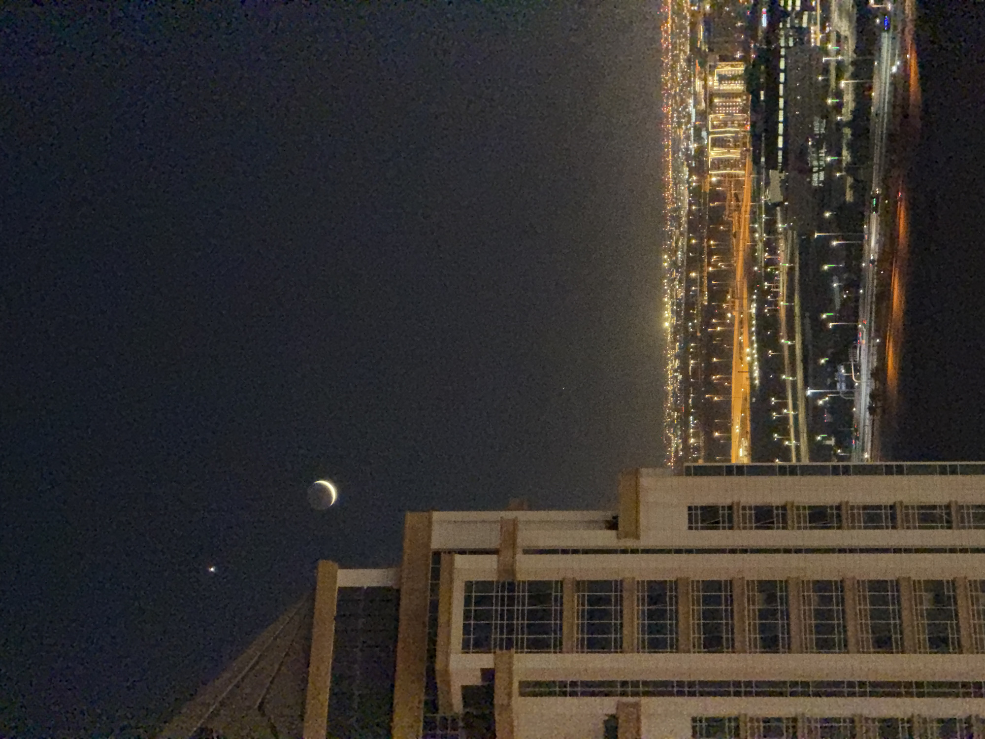 Doha skyline at night, from waterfront Ferris wheel to crescent moon