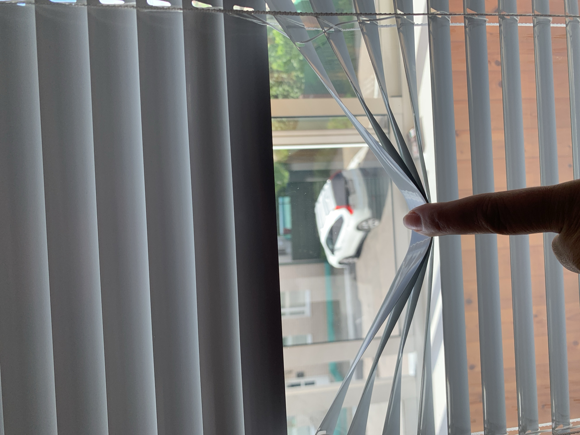 Peering through venetian blinds at parked car in Kapyĺ
