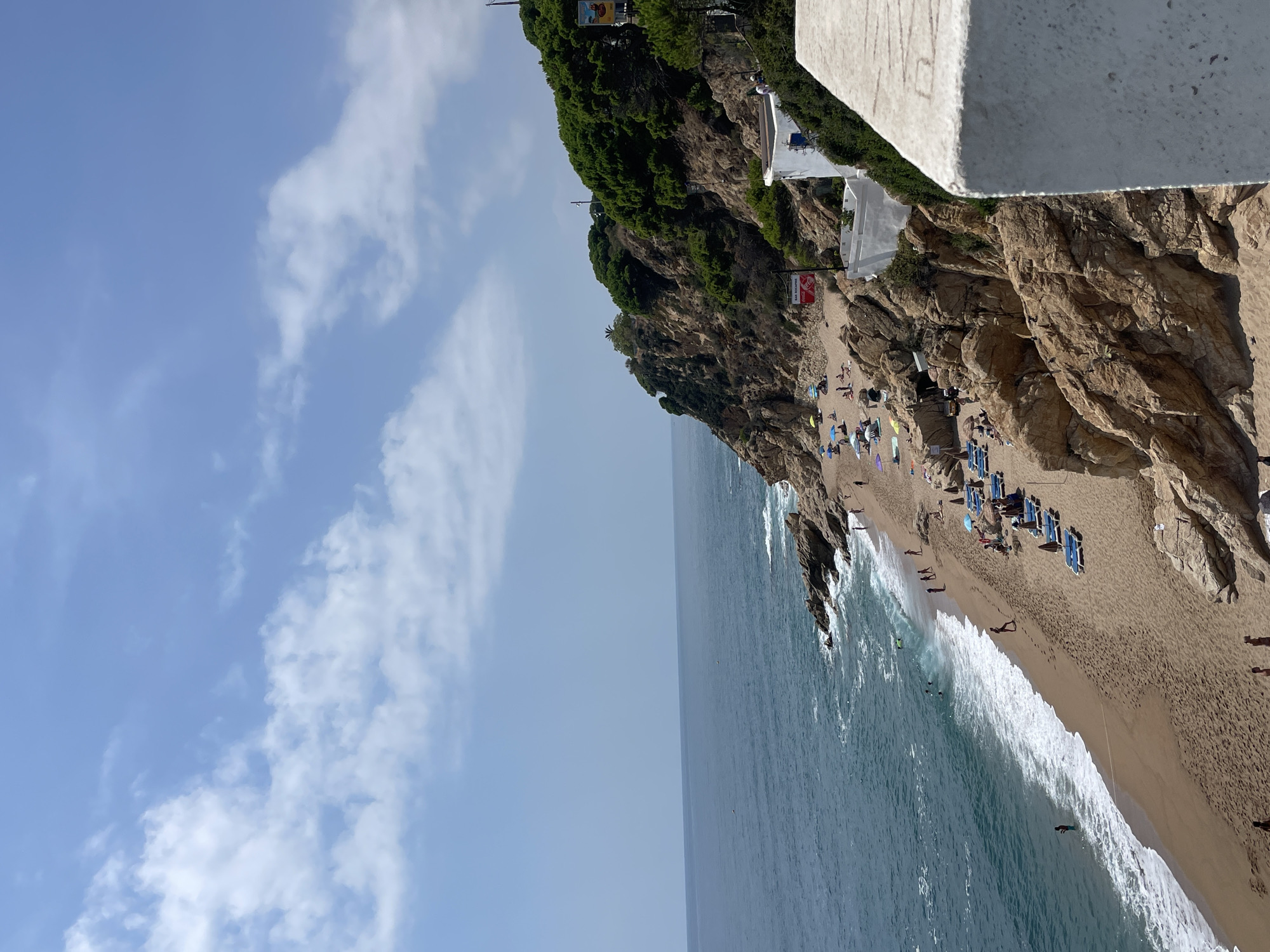 Crowded Calella beach on a summer day, ambulance on scene