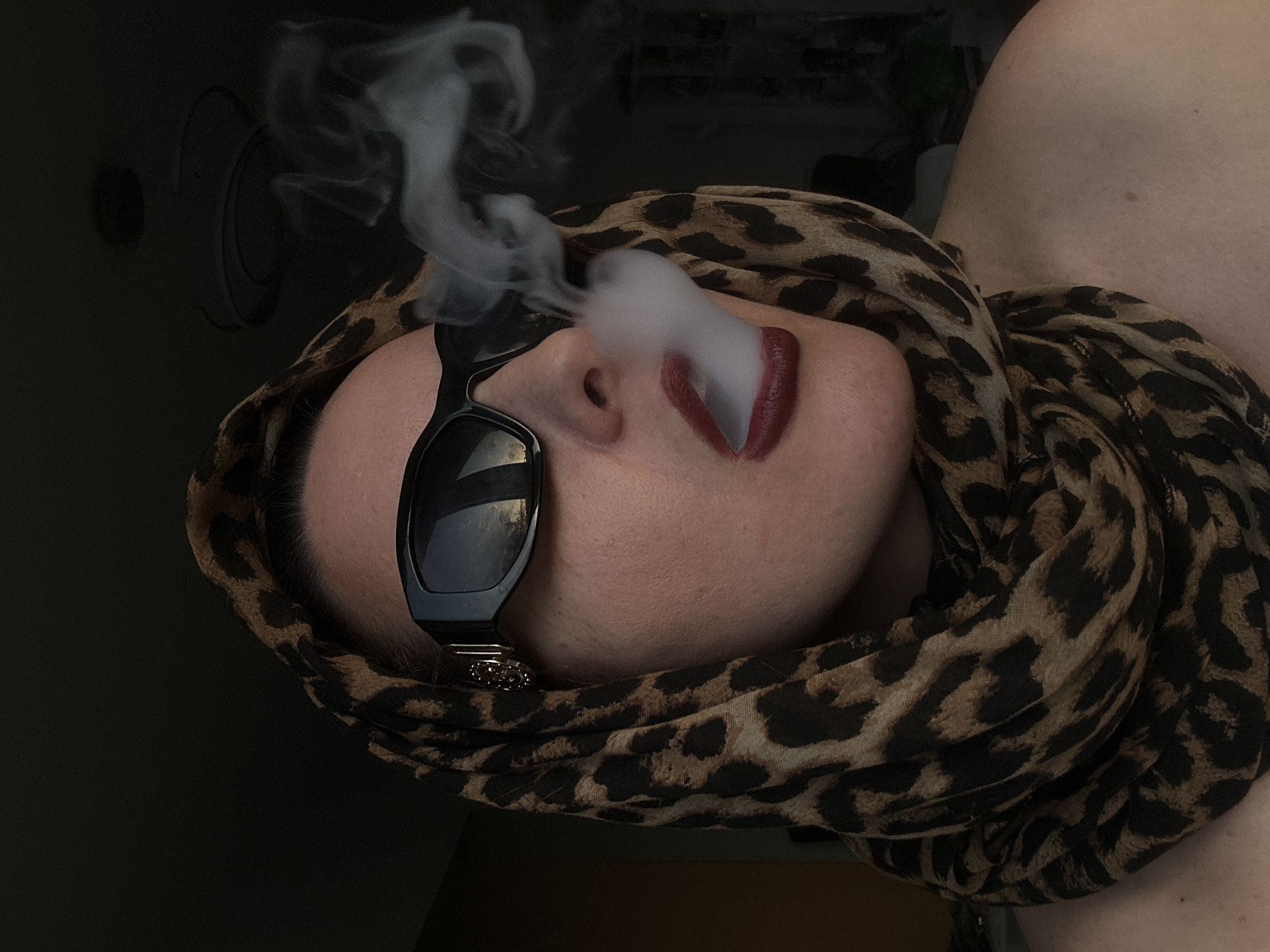 Person in leopard scarf vapes indoors in Riga