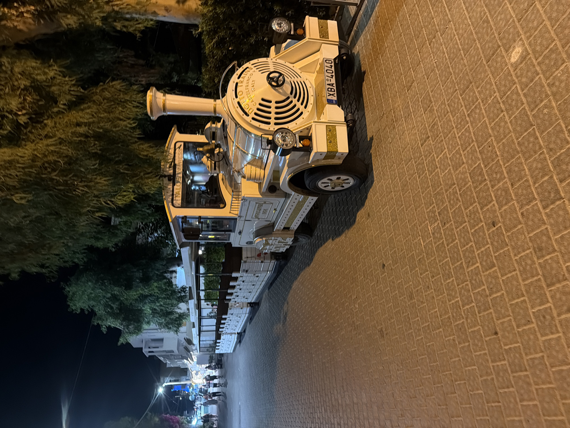 Tourist train parked on cobblestone streets in Georgioupoli at night