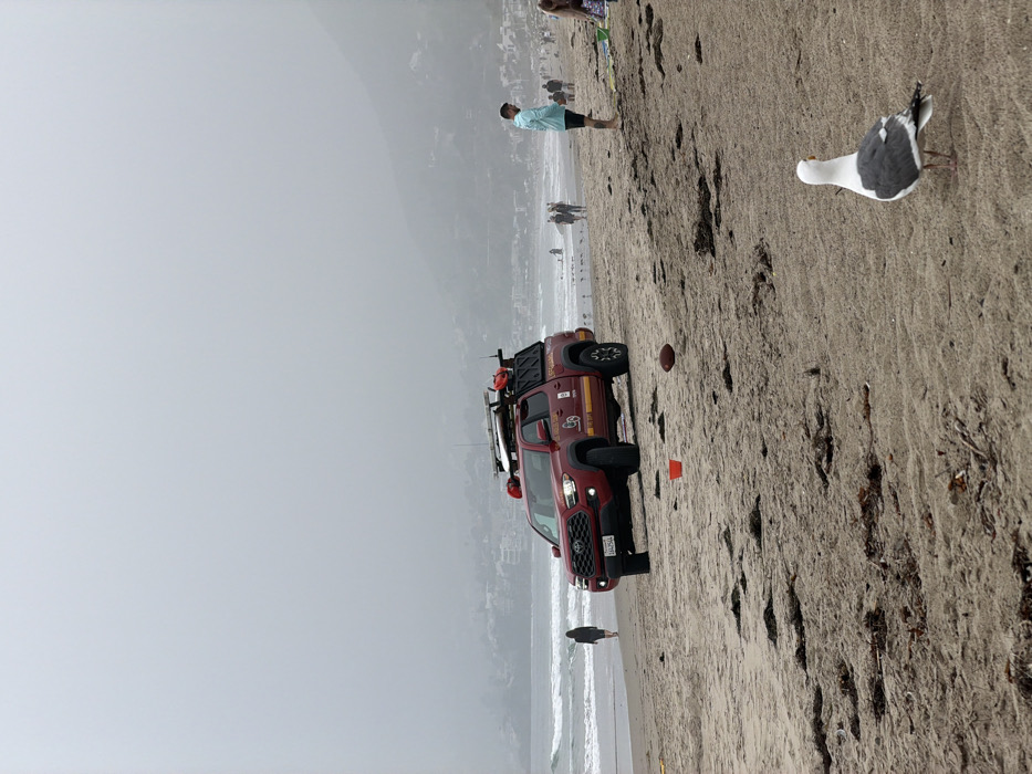 Evening beach activities continue under overcast skies in Malibu