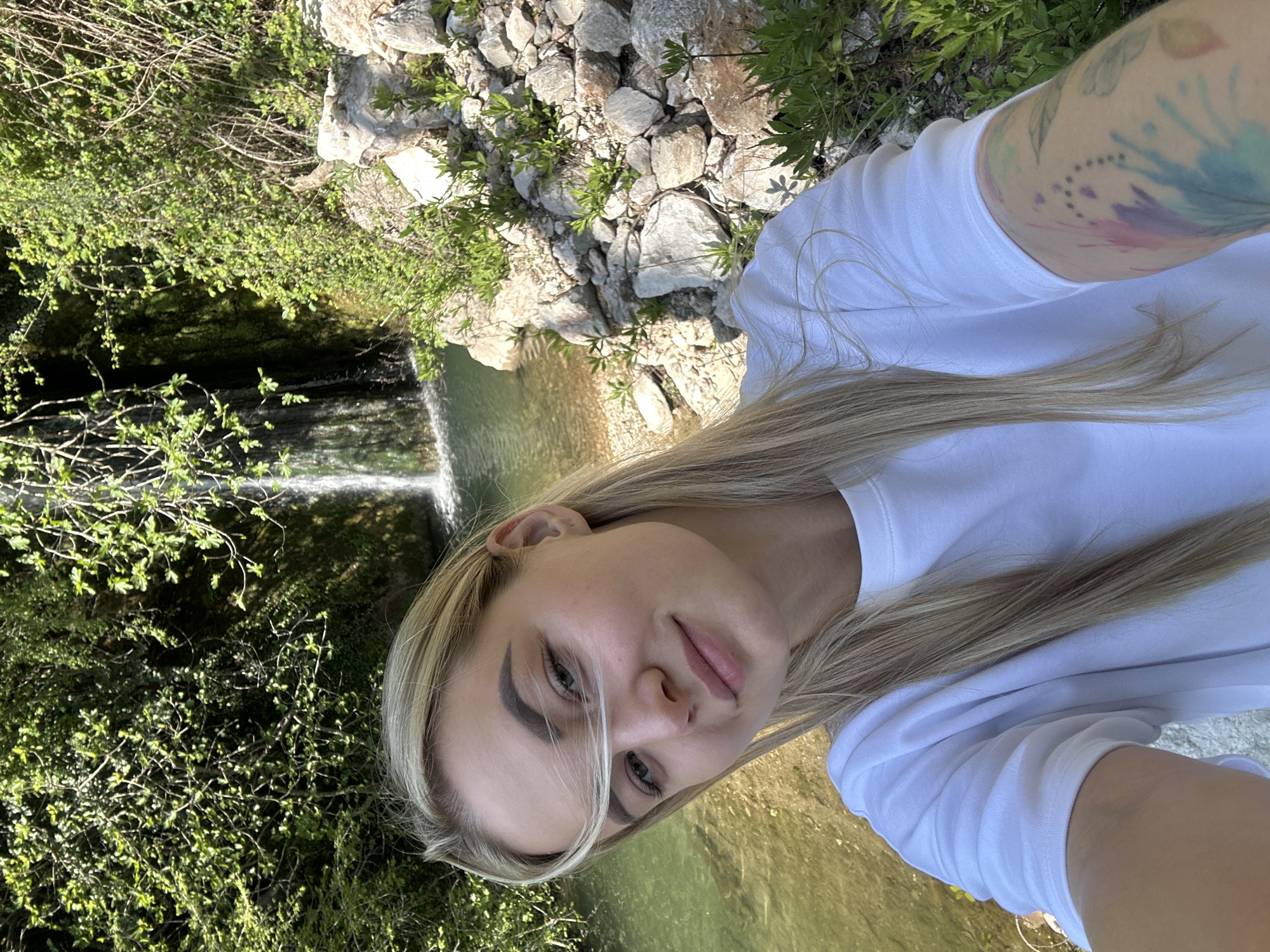 Tourist photographs waterfall selfie in Montenegro countryside