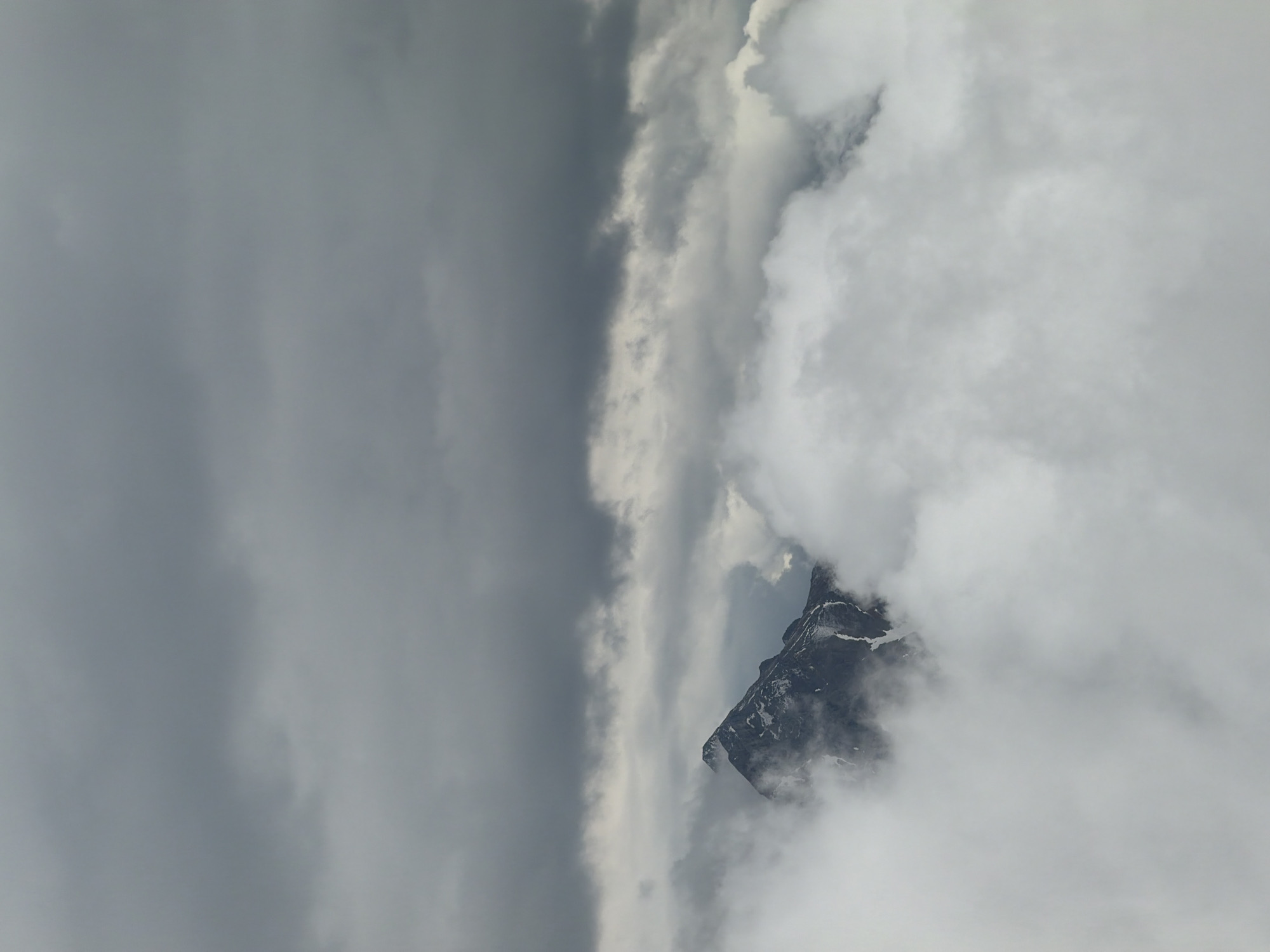 Mountain peak shrouded in dense clouds observed