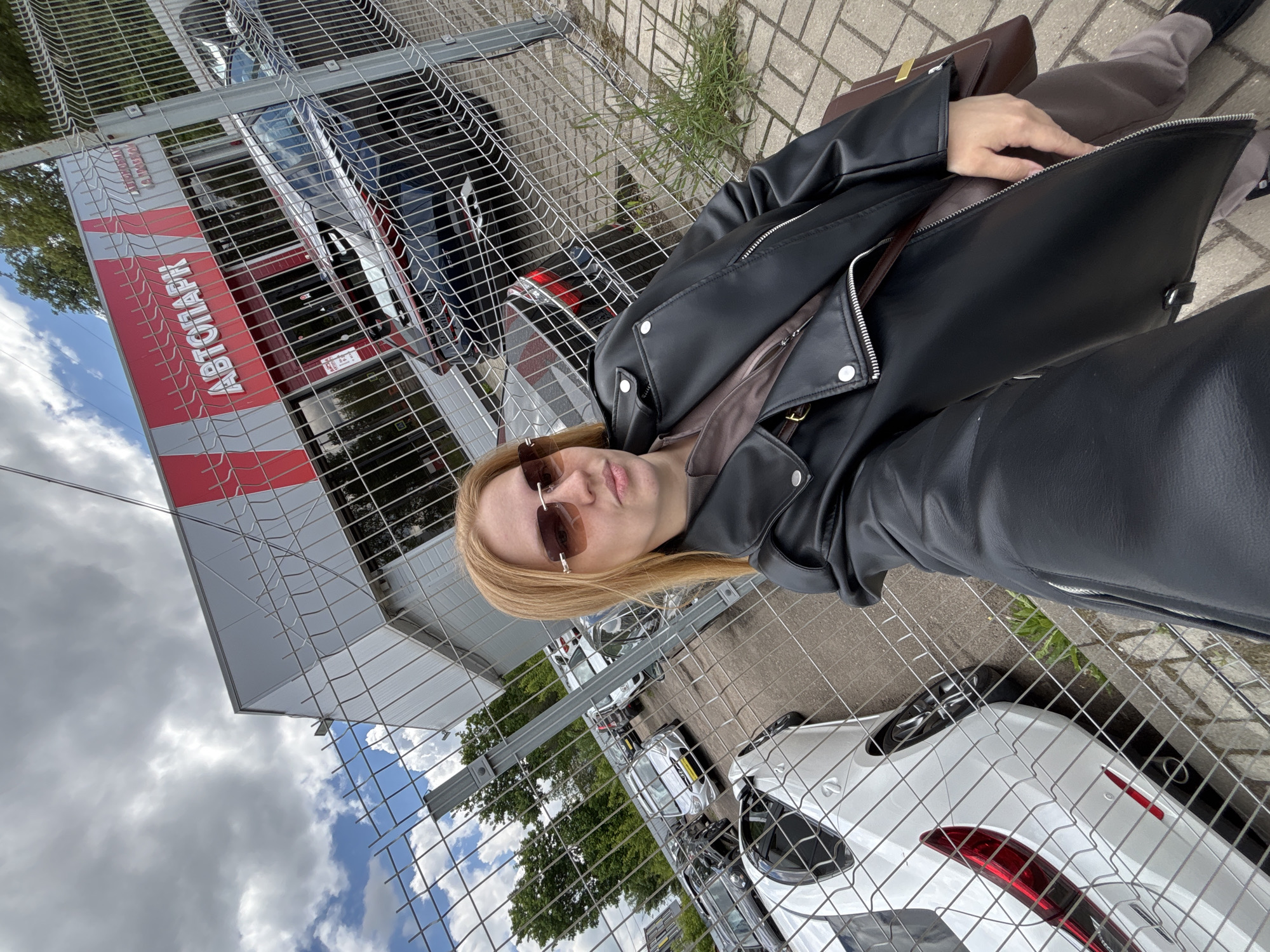 Woman sits on bench near autograph fence in Yaroslavl